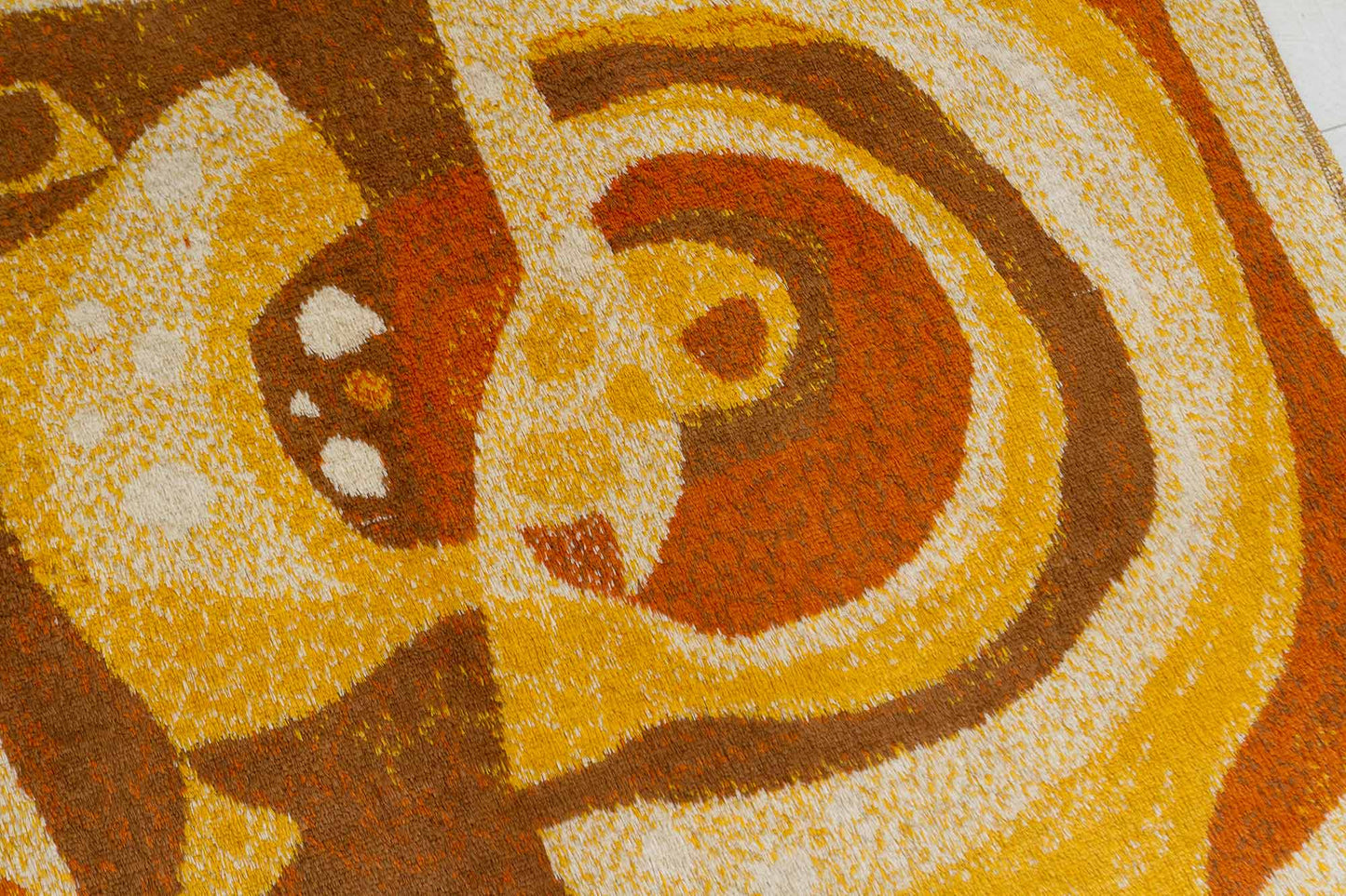 Closeup shot of a vintage mid century modern wall tapestry, showcasing the organic abstract design in orange, brown and beige colors and the fine pile structure of the vintage tapestry fabric
