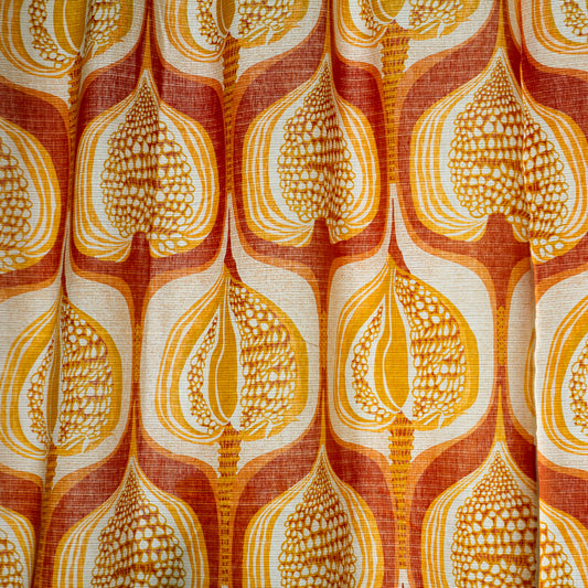 Close-up of vintage curtain pattern with organic, stylized seed pods or autumn leaves in orange, mustard and cream