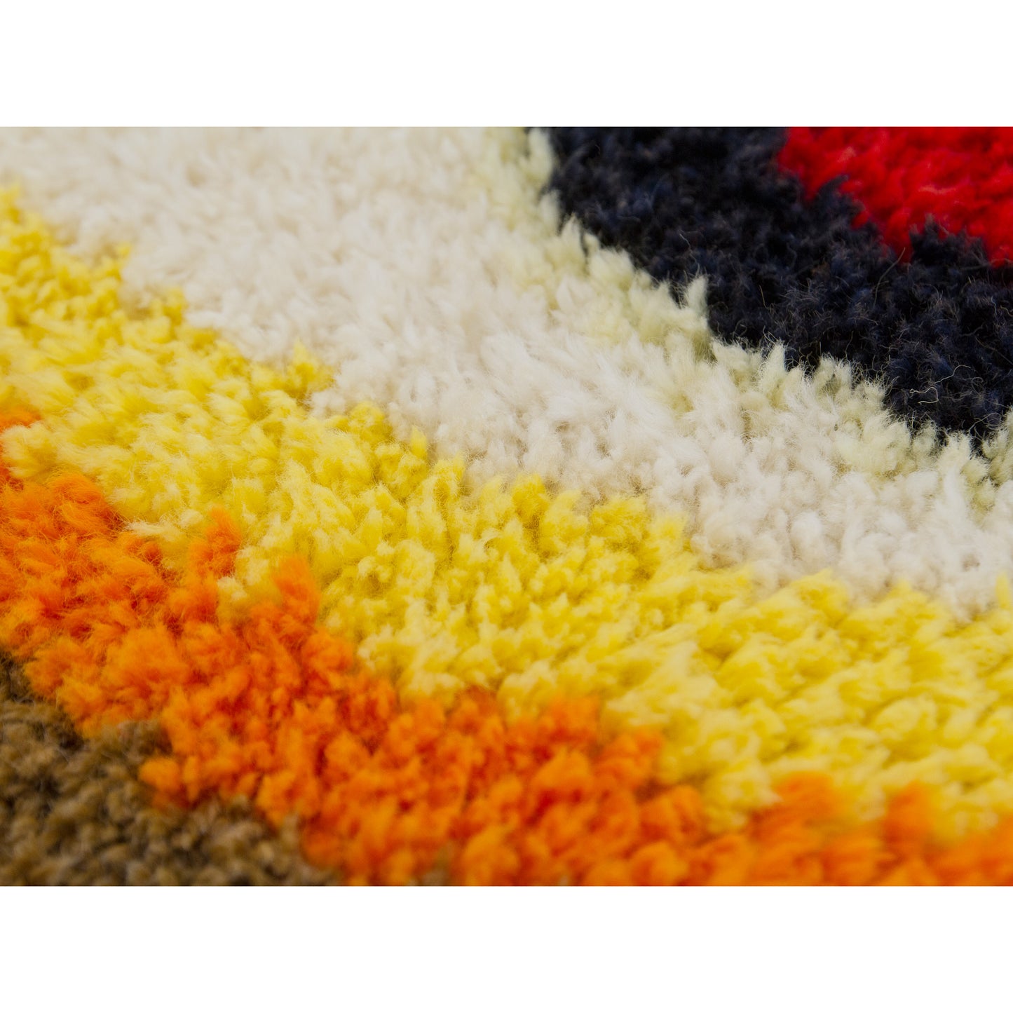 Extreme close up view, capturing the plush, thick piles of the abstract op-art accent rug. High quality vintage craftmanship from 1970s.