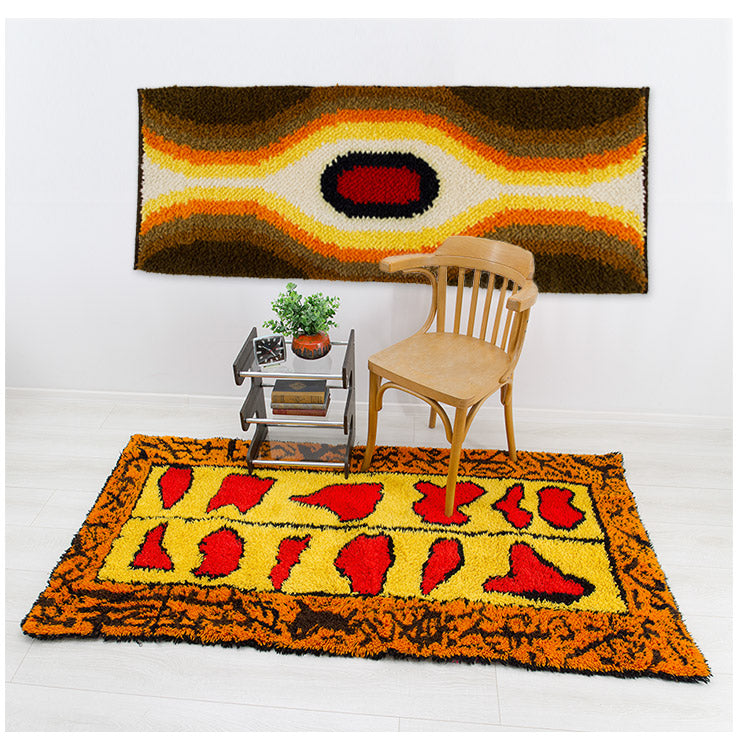 Styled room with vintage multi-purpose rugs displayed as wall tapestry and accent rug on the floor. The bold, striking design add a strong mid century vibe to the room.