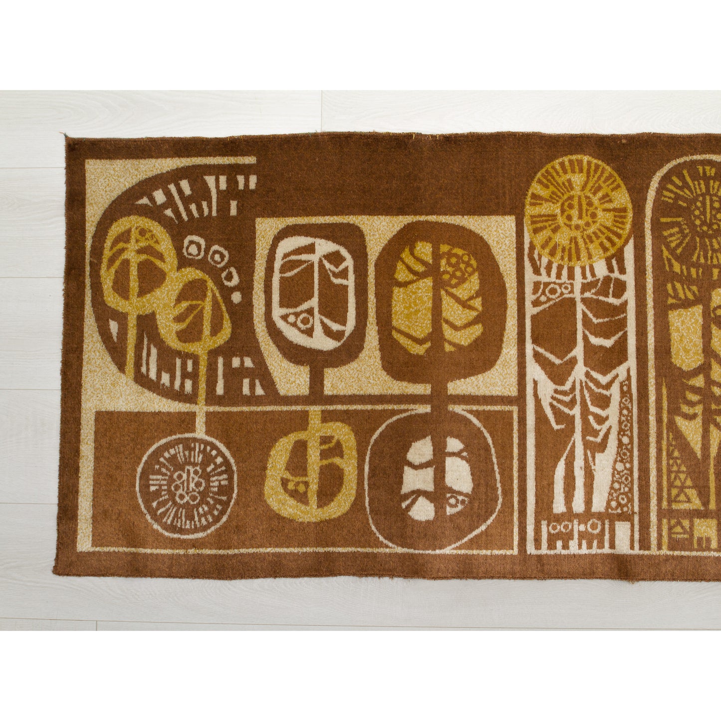 Close-up of the tapestry's left section showing round, seed-head or tree motifs. Rich chocolate brown background with harvest gold and beige woven accents. Authentic 1960s graphic design.
