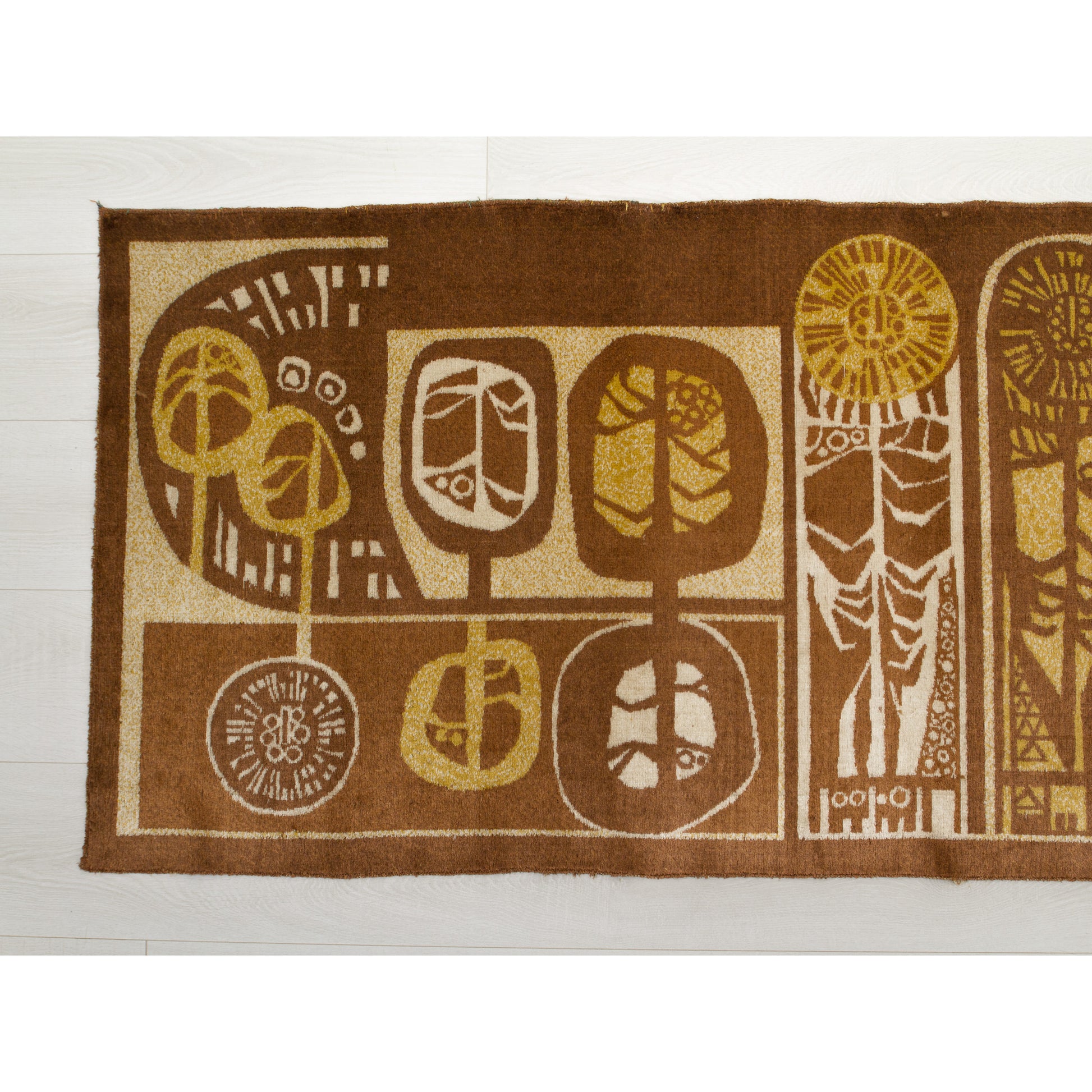 Close-up of the tapestry's left section showing round, seed-head or tree motifs. Rich chocolate brown background with harvest gold and beige woven accents. Authentic 1960s graphic design.
