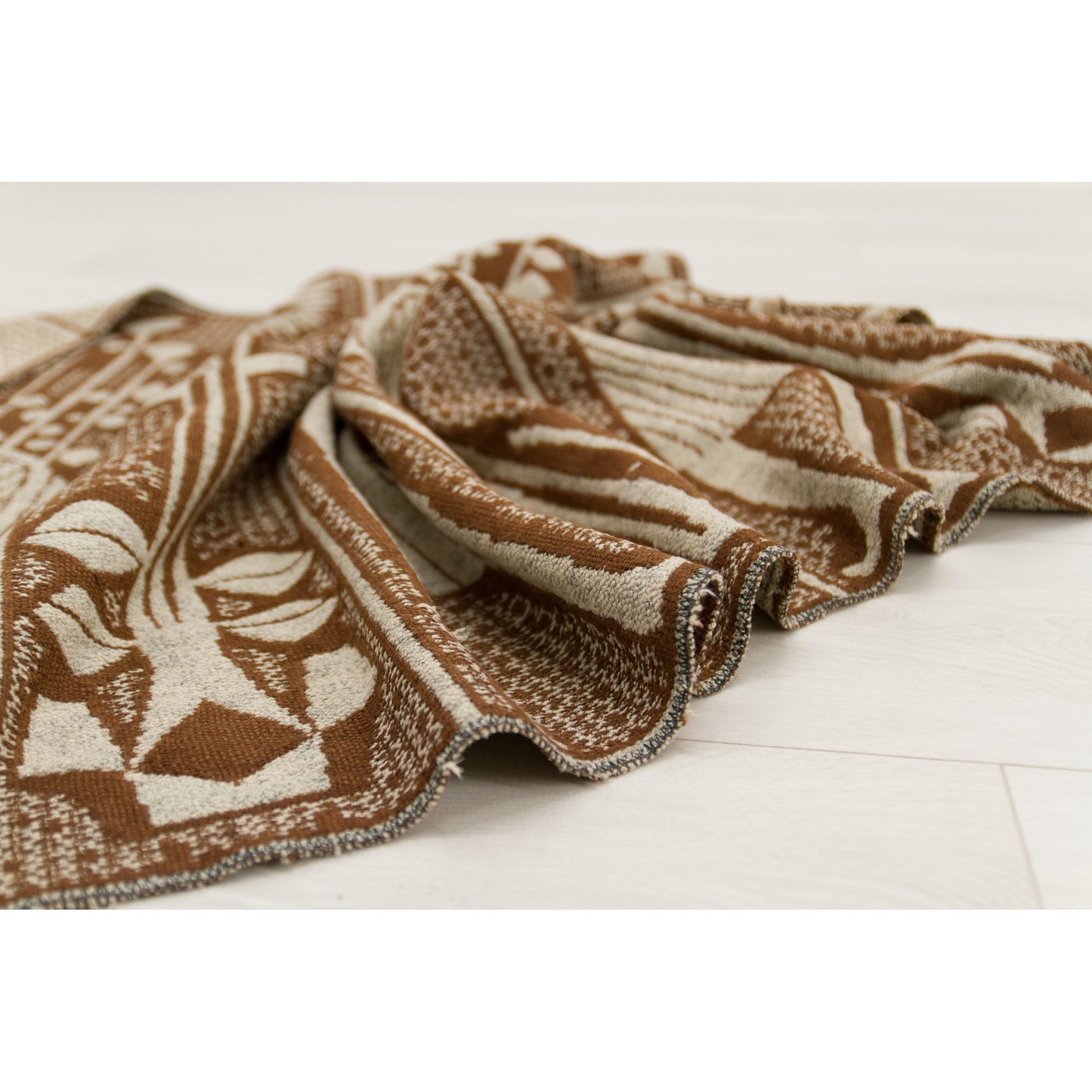 Vintage tapestry draped, highlighting its heavy weight and fluid movement. Perfect texture to soften brutalist or industrial concrete interiors.