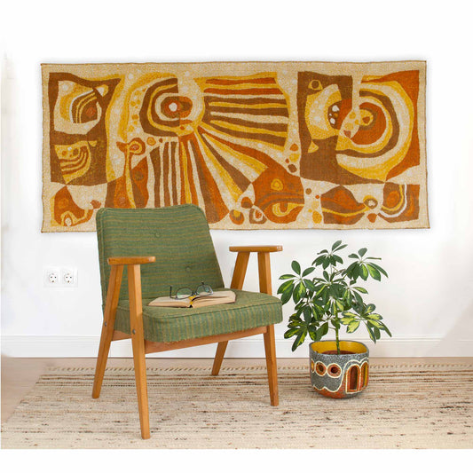 1960s mid century modern wall tapestry styled with a vintage green armchair and a potted plant, large vintage tapestry hanging on the wall with abstract design