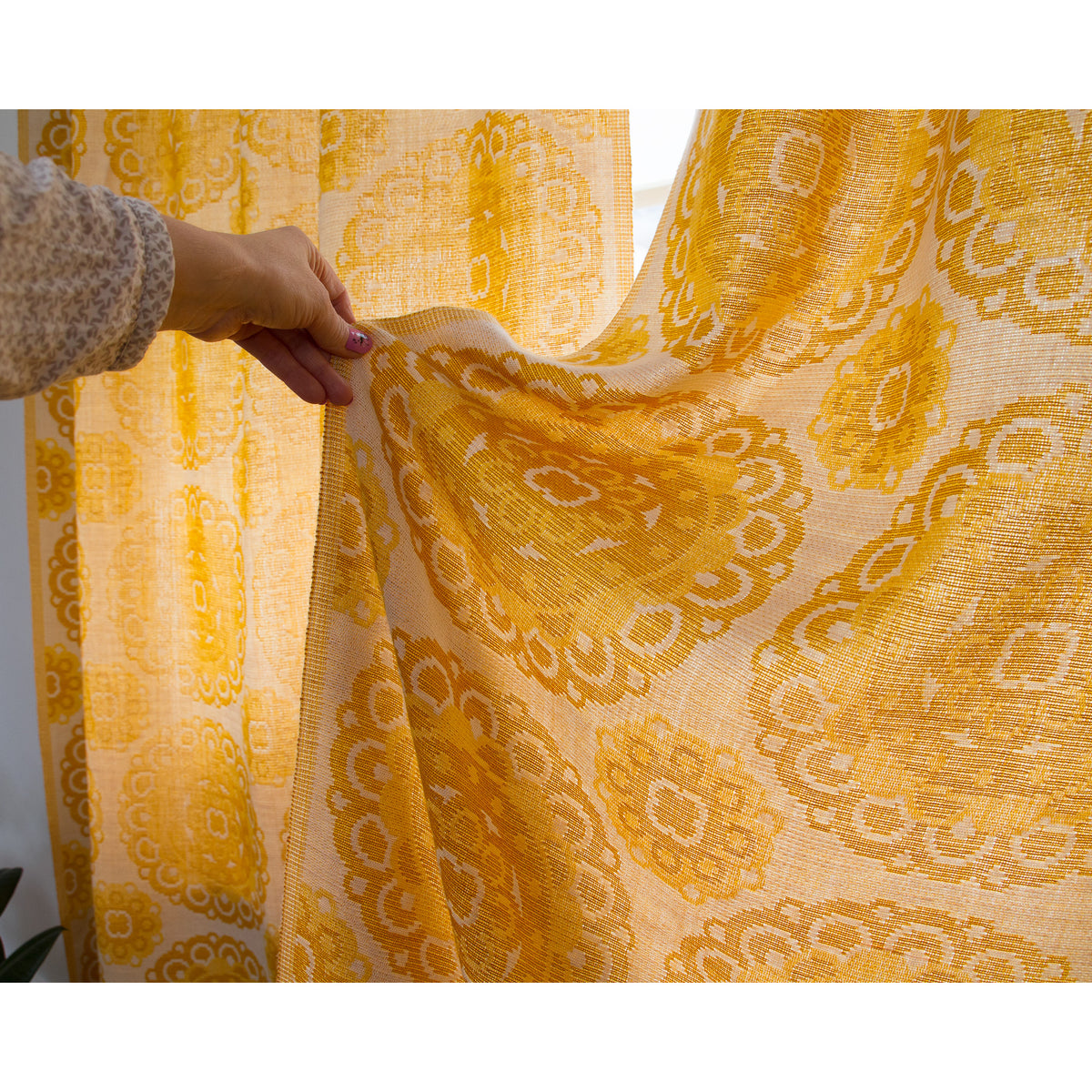 Close-up of 1970s jacquard curtain panel with woven yellow and cream flower medallion design.