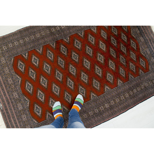 Person standing on a 4x7 vintage hand-knotted silk rug to show its size - the rug is in perfect and ready-to-use condition