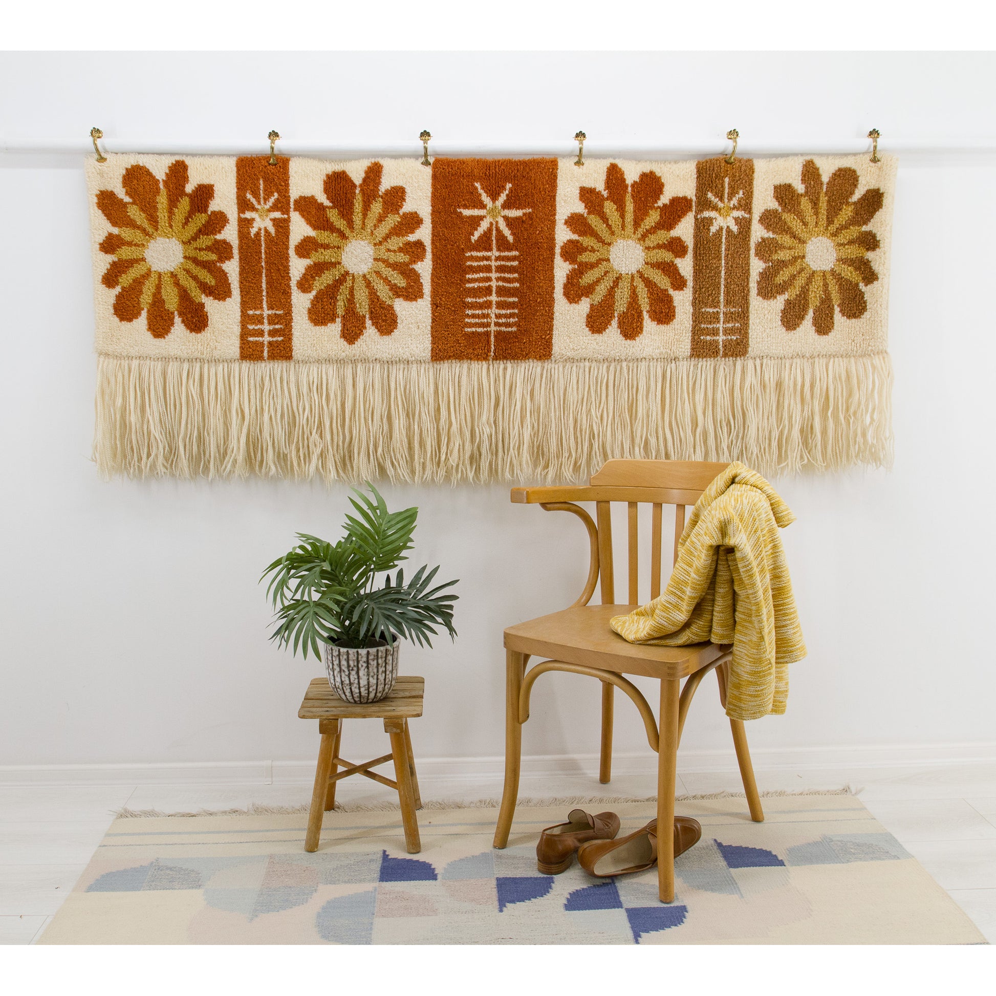 Styled shot of the vintage wall hanging in a bohemian corner with a wooden bentwood chair. Demonstrates the cozy, nostalgic "Laurel Canyon" aesthetic.