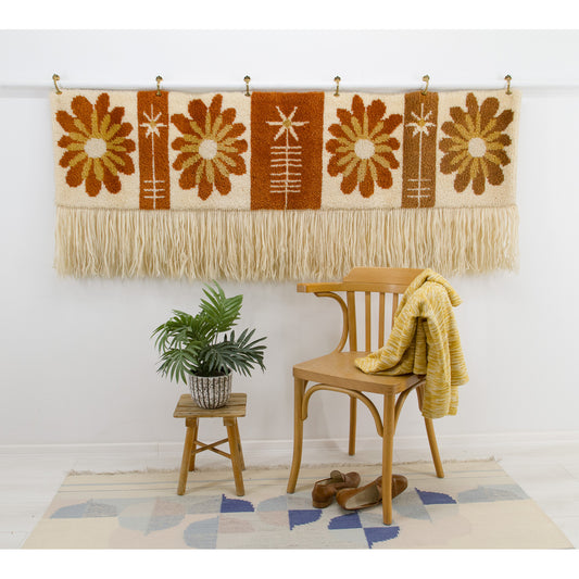 Styled shot of the vintage wall hanging in a bohemian corner with a wooden bentwood chair. Demonstrates the cozy, nostalgic "Laurel Canyon" aesthetic.