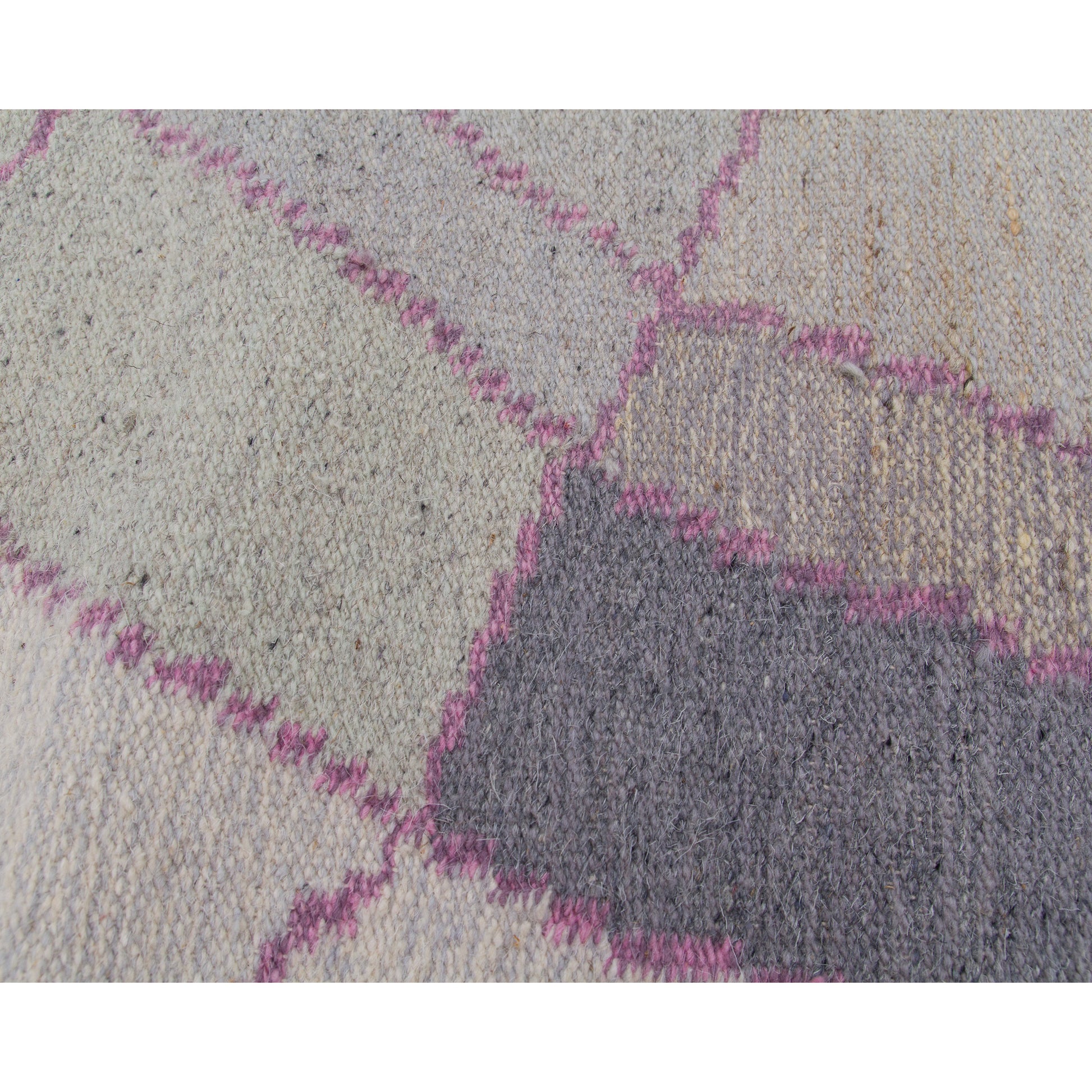 Extreme macro photo capturing the gorgeous interplay of heathered beige and dusty rose yarn lines forming the vintage tapestry's structural geometry.