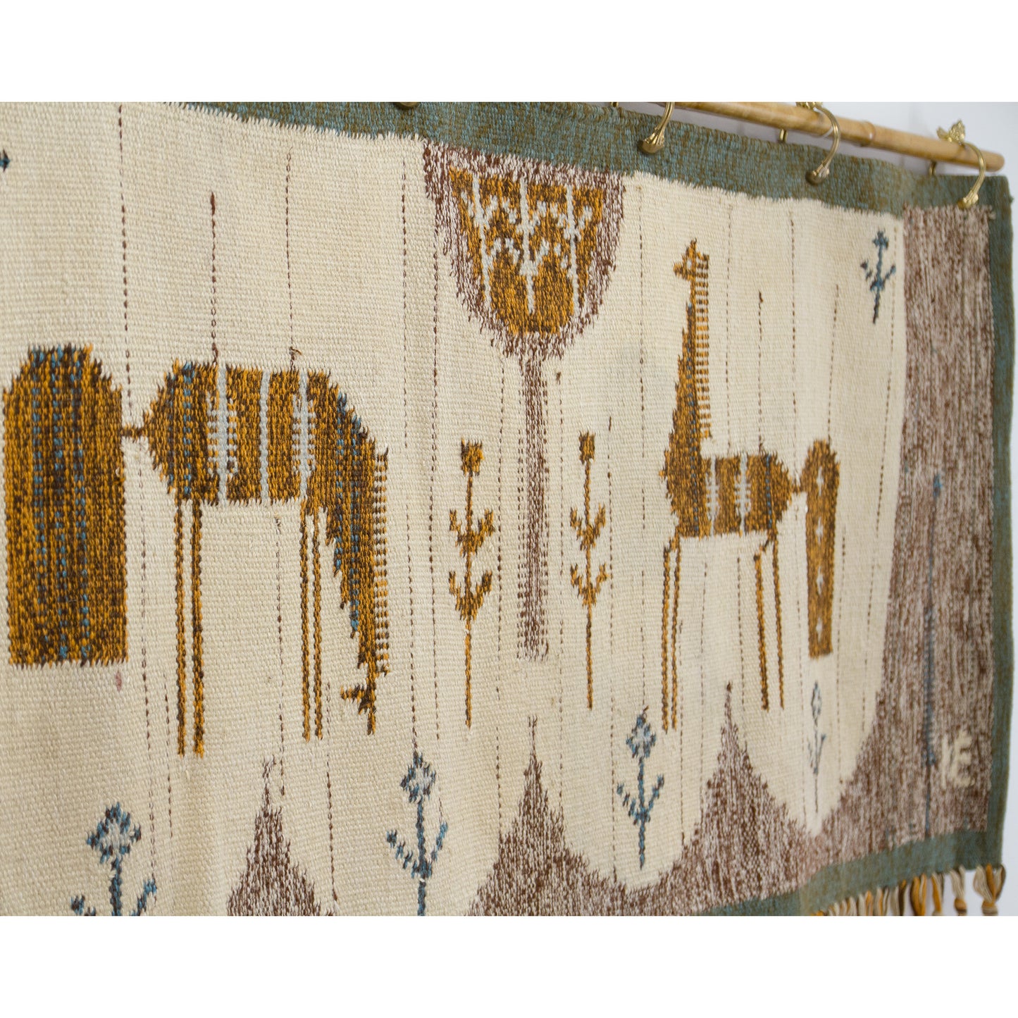 An angled photography perspective highlighting the sturdy, incredibly high-quality flatweave texture of the authentic 1970s vintage wool wall hanging.