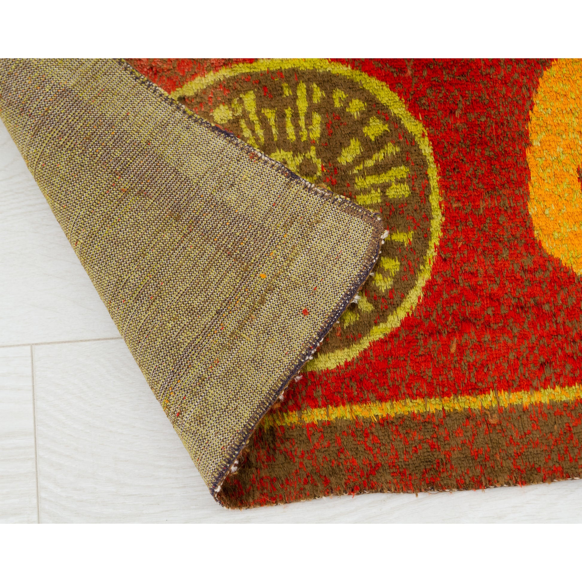 The mid century rug flipped at the corner, contrasting the heavy, coarse woven durability of the underside with the incredibly soft velour-style surface.