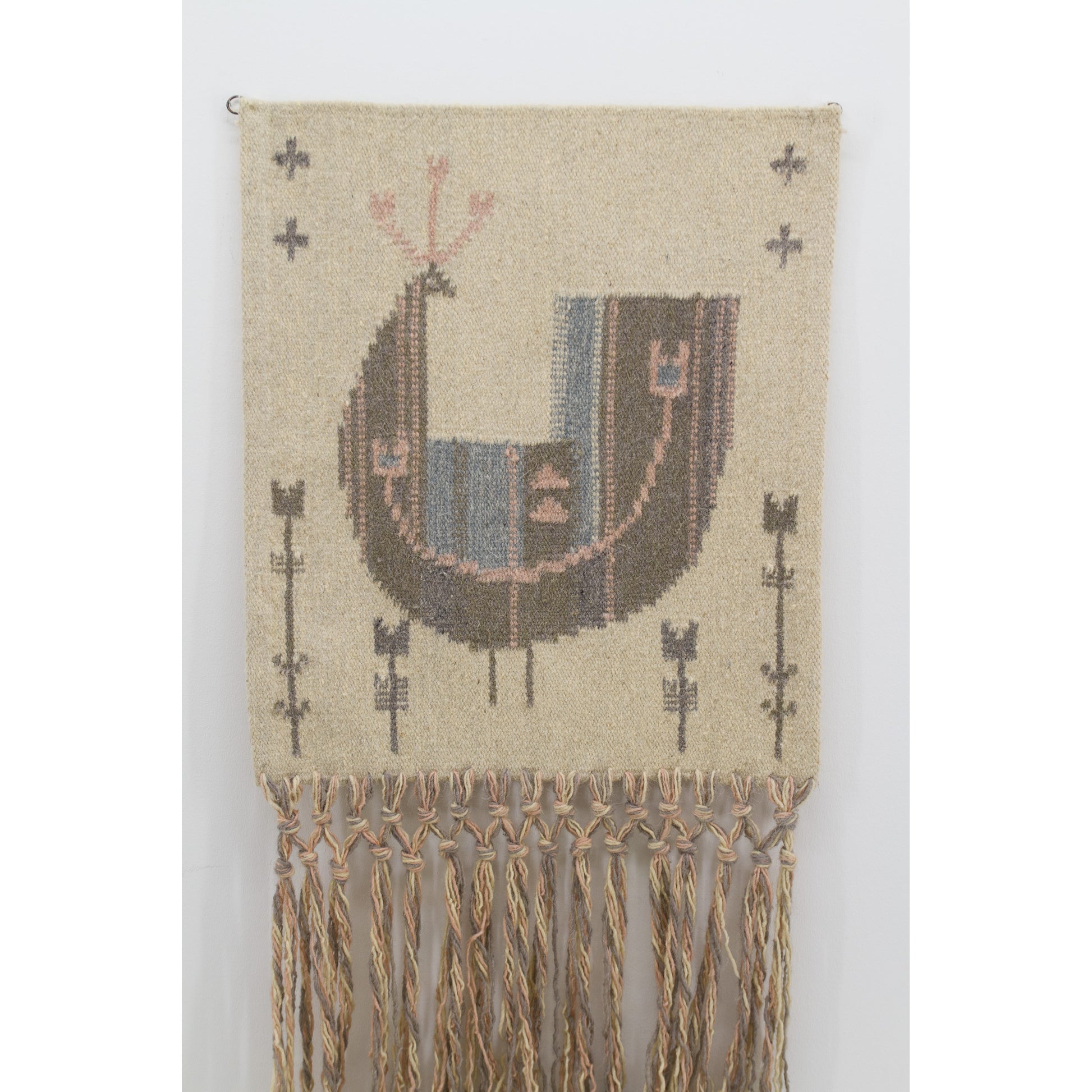 Closer view framing the flatweave fabric center. Shows a stylized greyish-blue bird motif against a muted beige background. Authentic mid-century pan-folkloric design.