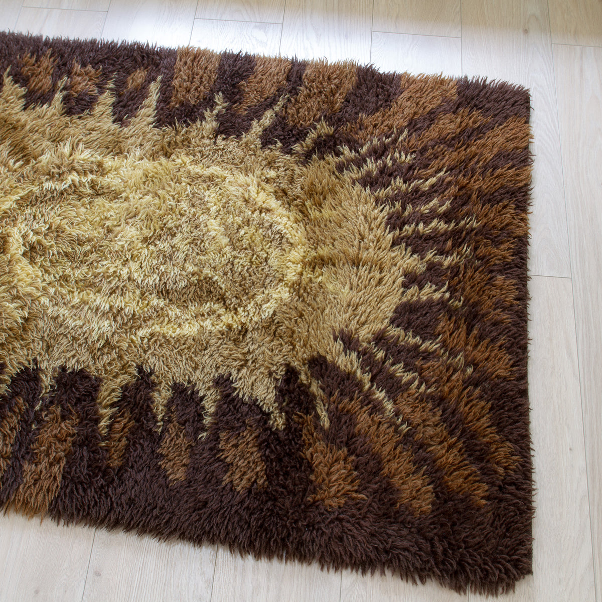 70s vintage shag rug with a sunburst pattern in shades of brown and beige, laid out - perfect accent for a serene japandi style home