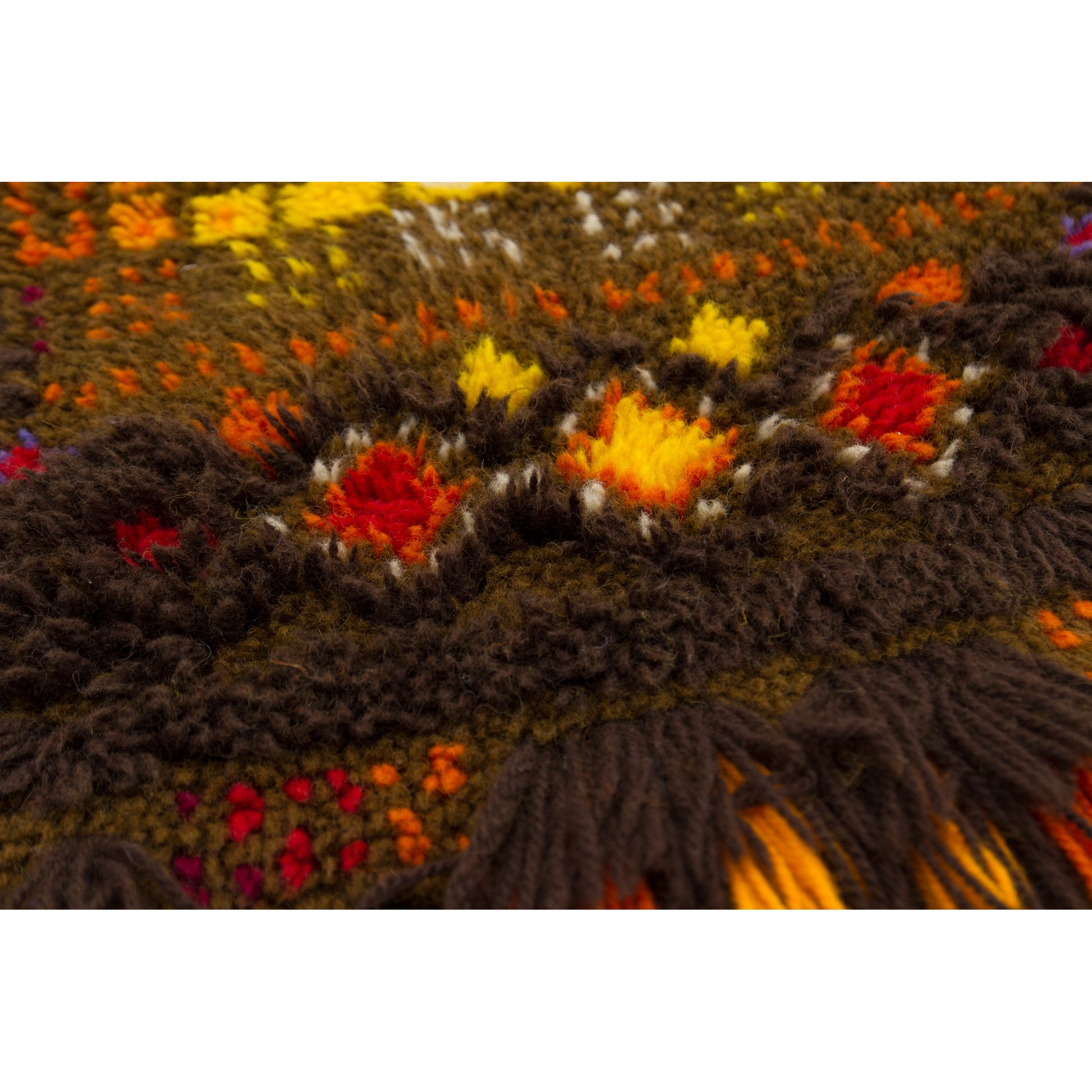 A tight macro detail on the center band of the rug, focusing on the vibrant red, orange, and yellow diamond and square shapes woven securely into the dark base.