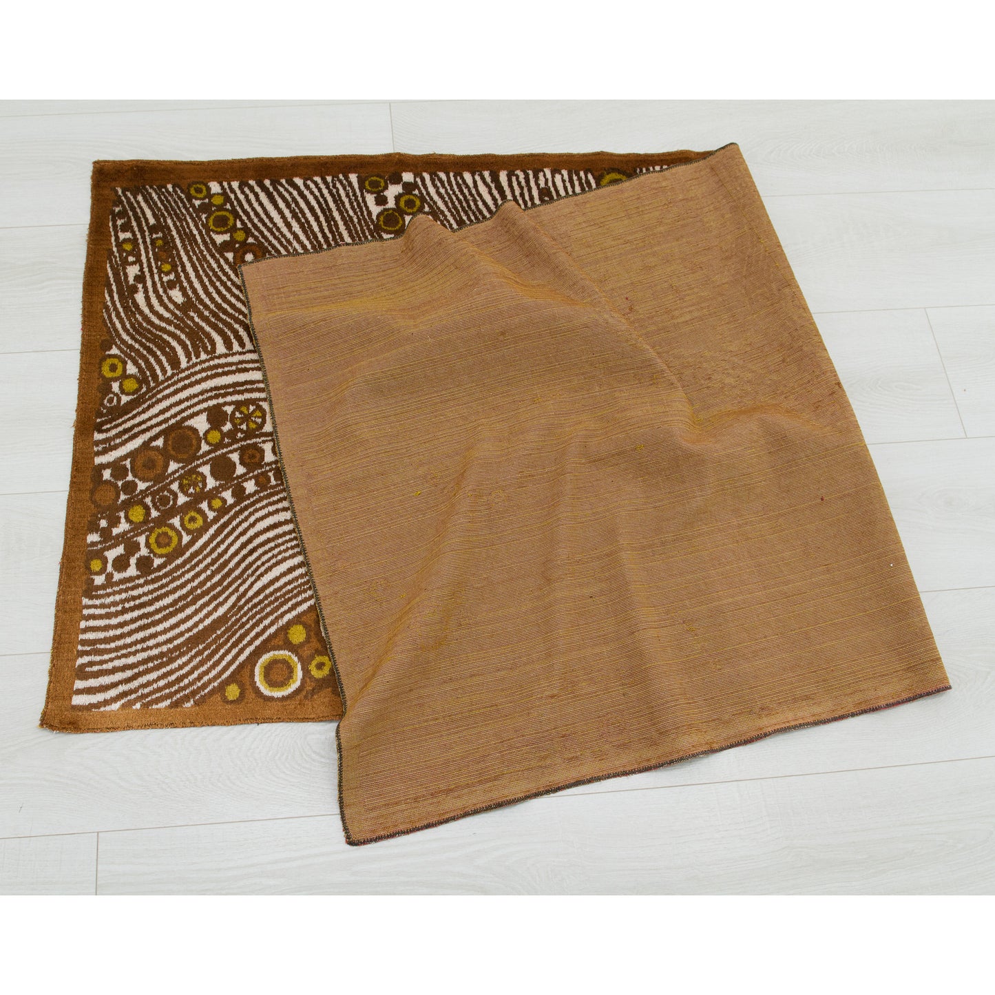 The oversized 1960s tapestry folded elegantly on a white floor to verify it is immaculately clean, professionally maintained, and free of any hidden stains or age spots.
