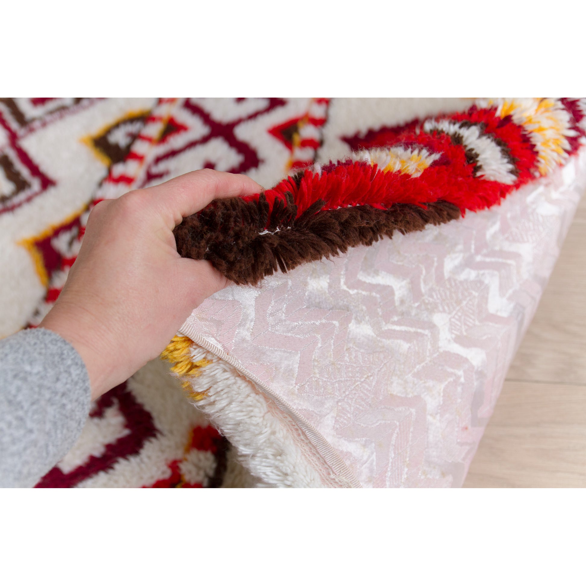 Hand lifting the corner of the retro shag piece to demonstrate its thick, substantial, heavy-weight drape (approx 6 lbs) and amazing vintage preservation.