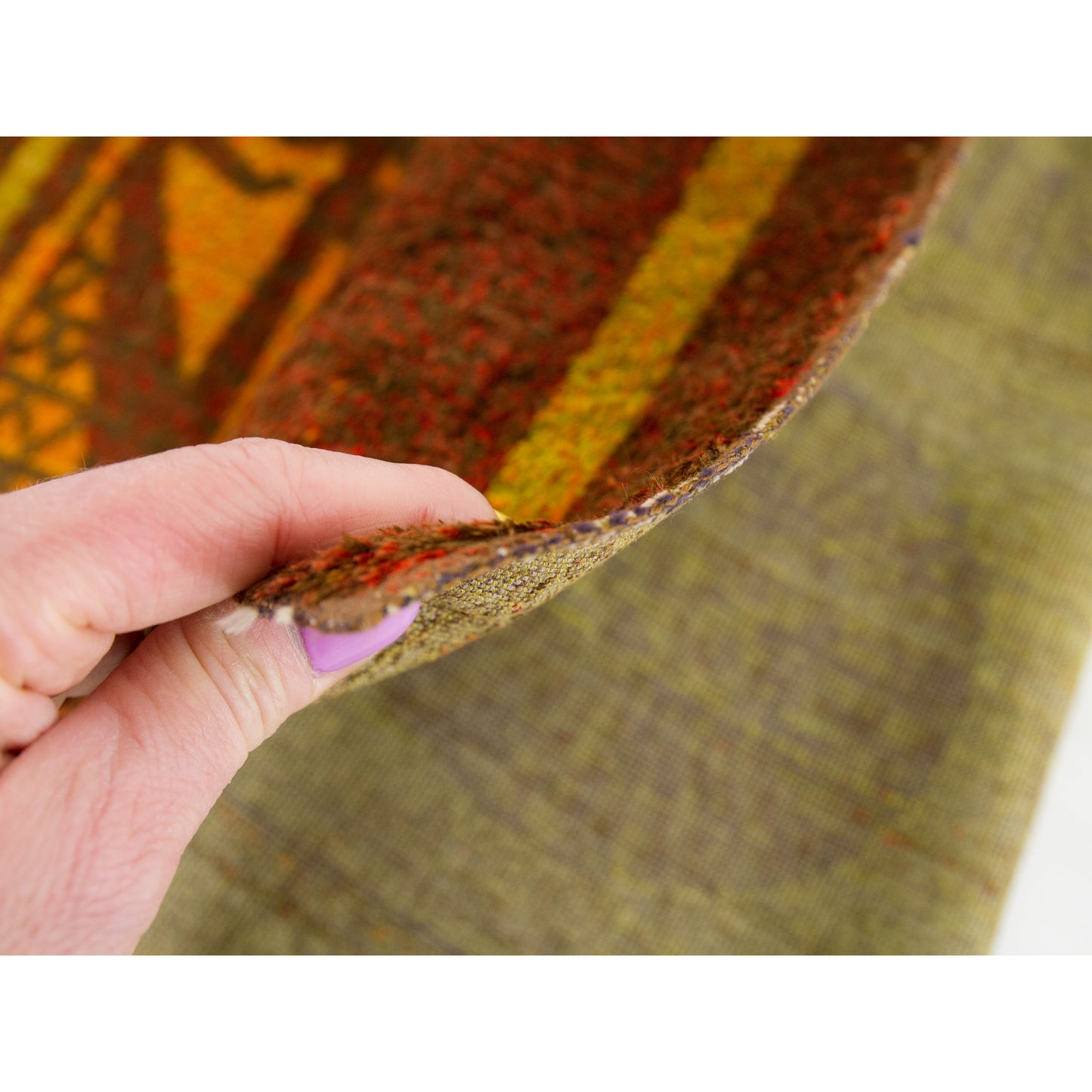 Tapestry held gently between fingers to display its medium-weight structural thickness. Capable of being hung easily or taking gentle foot traffic.