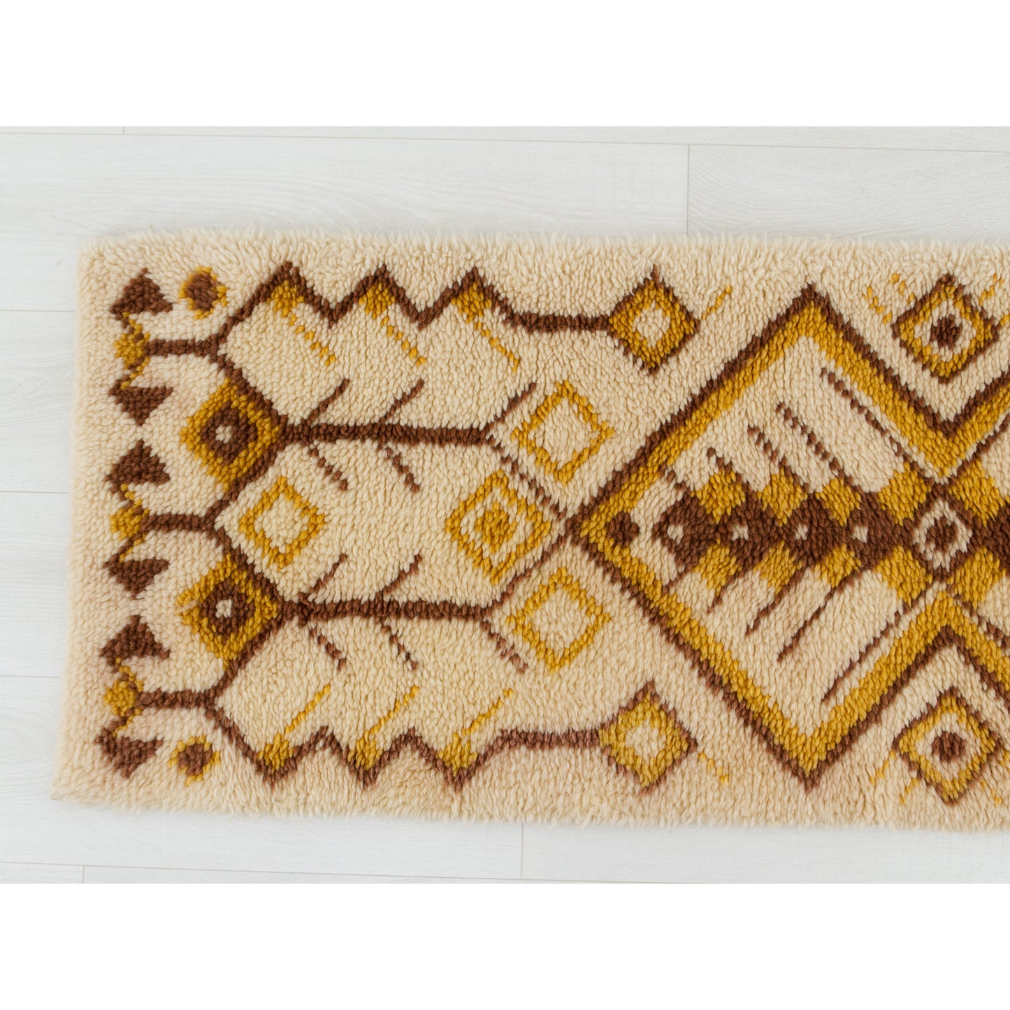 Straight downward gaze at the left quadrant revealing how seamlessly the mustard yellow retro shapes flow against the deep chocolate brown geometry.