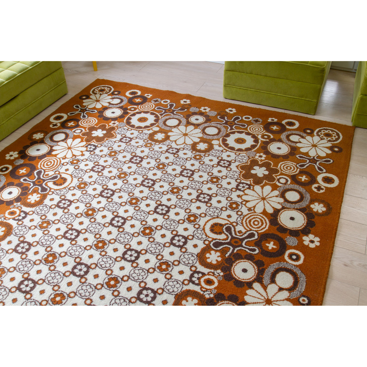 Full view of a vintage flower power rug with bold floral border and small tile-like flower pattern in the center