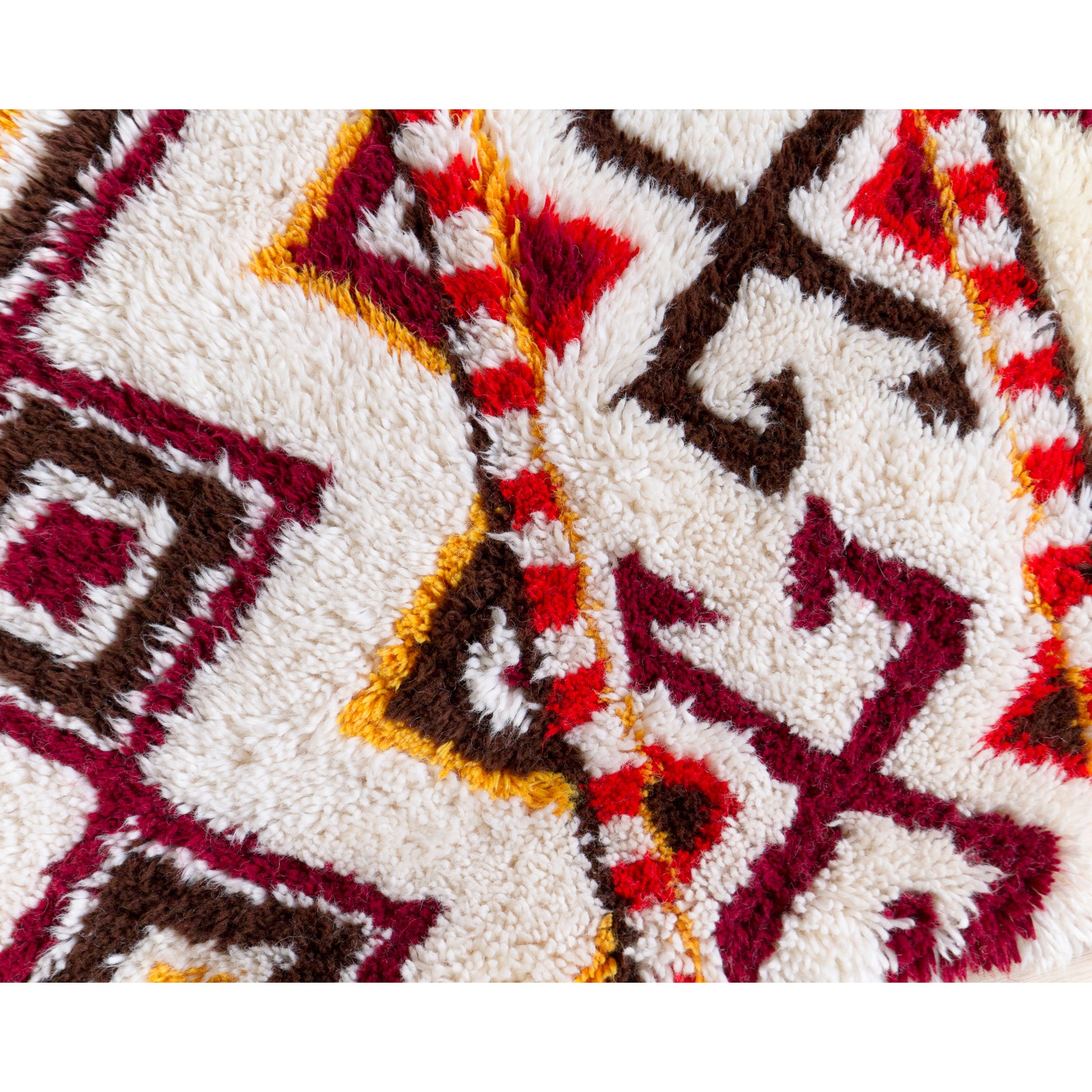 Macro close-up of the extra soft, exceptionally thick cotton pile texture on the 1970s geometric latch hook wall tapestry.