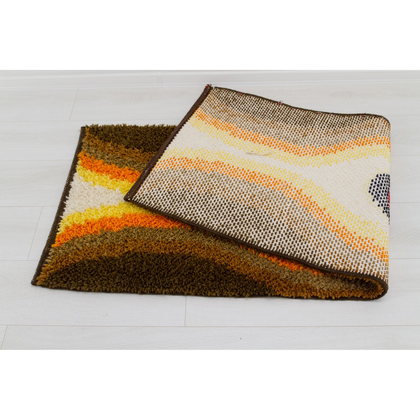 The folded retro tapestry highlights its flexibility and the heavy bold color-blocking construction and the sturdy woven backing.
