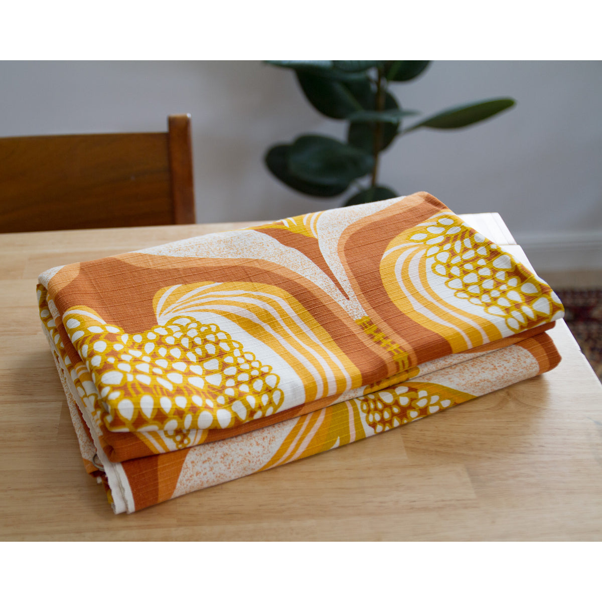 Folded vintage curtains in warm autumn colors on a wooden table