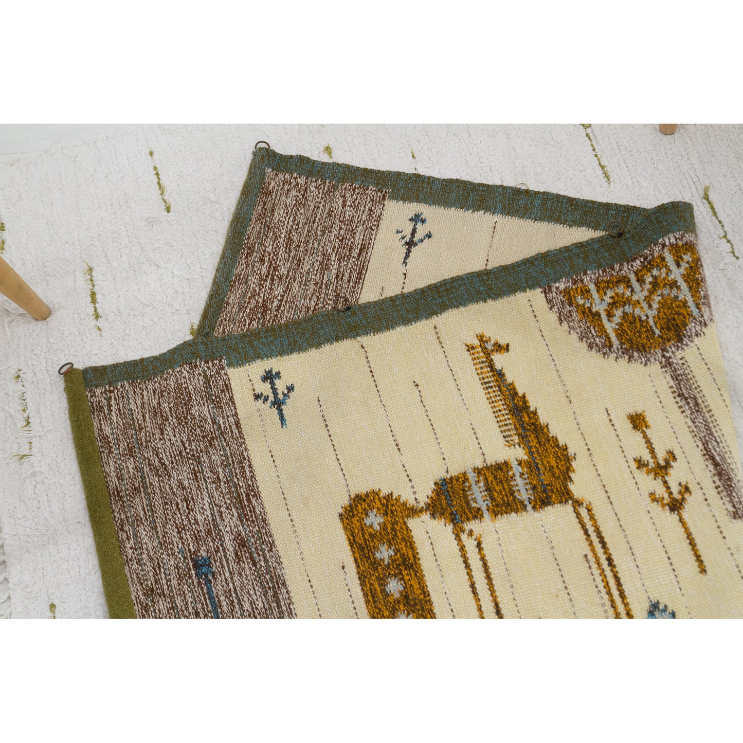 The tapestry is laid completely flat on the floor and halfway folded over upon itself, proving that the vibrant horse pattern is identical and reversible on both sides.
