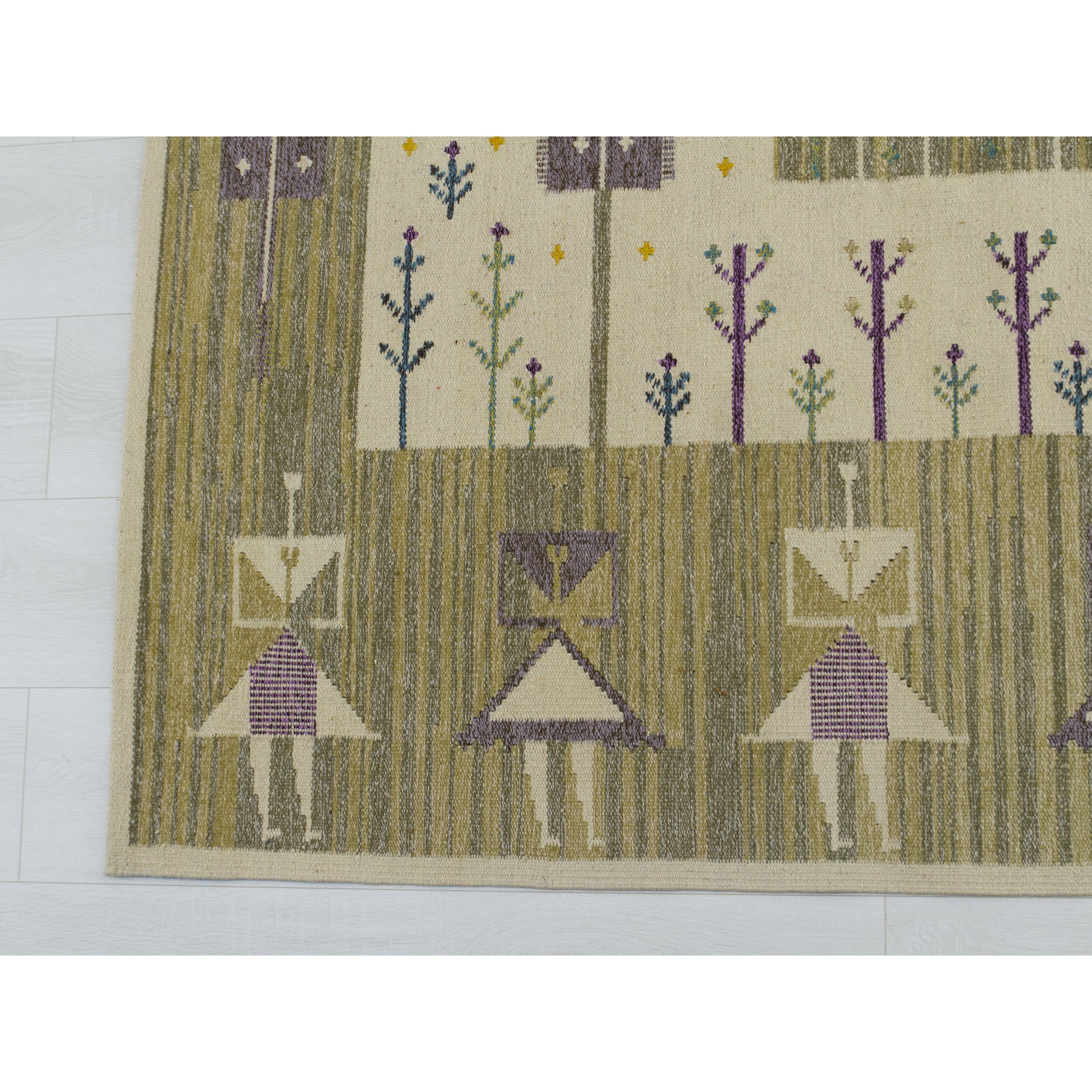 Detailed macro view of stylized female human figures woven into the wool rug using creamy beige, purple, and green yarn.