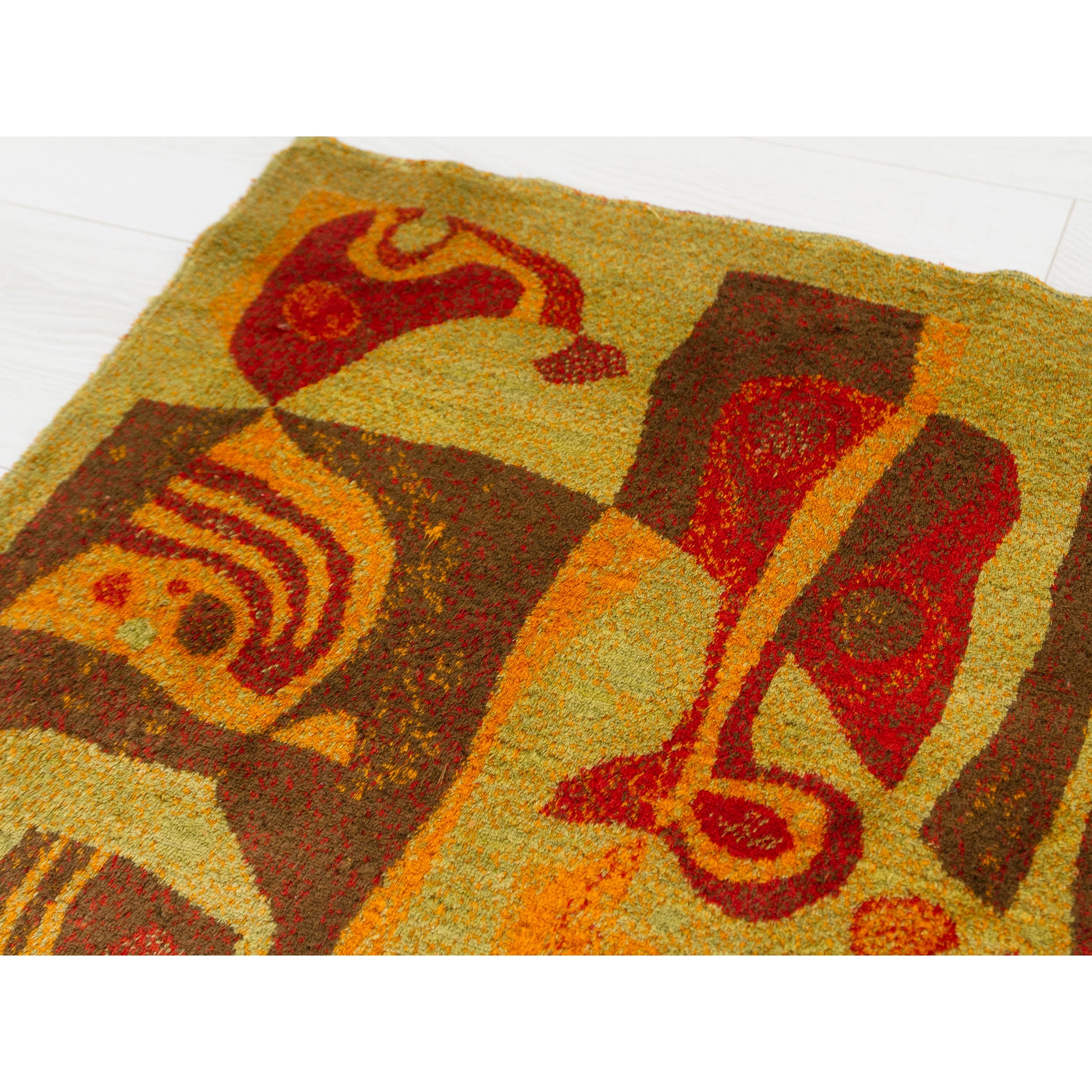 Close-up of the dense abstract motives featuring amorfphous shapes. Vivid burnt orange, red, and harvest gold velvet pile on a lime green background.