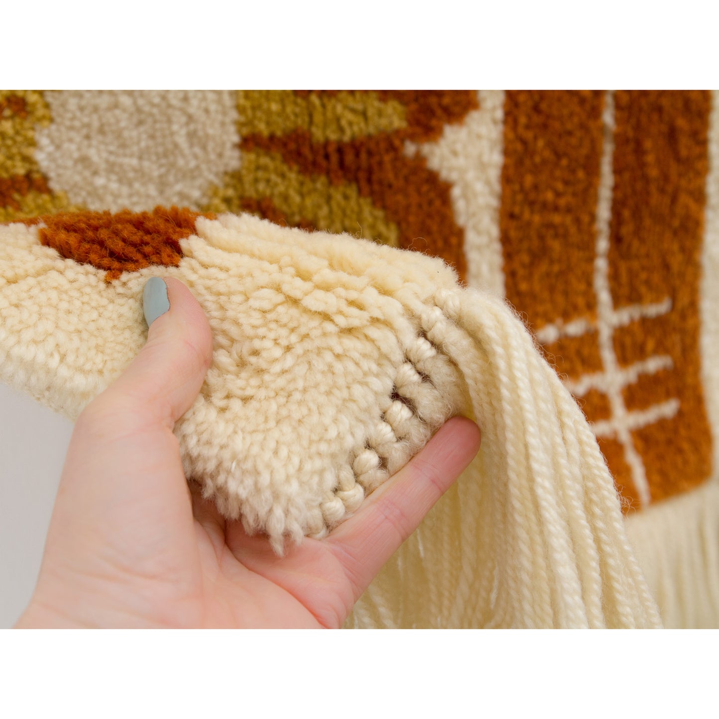 Extreme close-up of the dense wool knots. The thick texture provides acoustic dampening and warmth for the home.