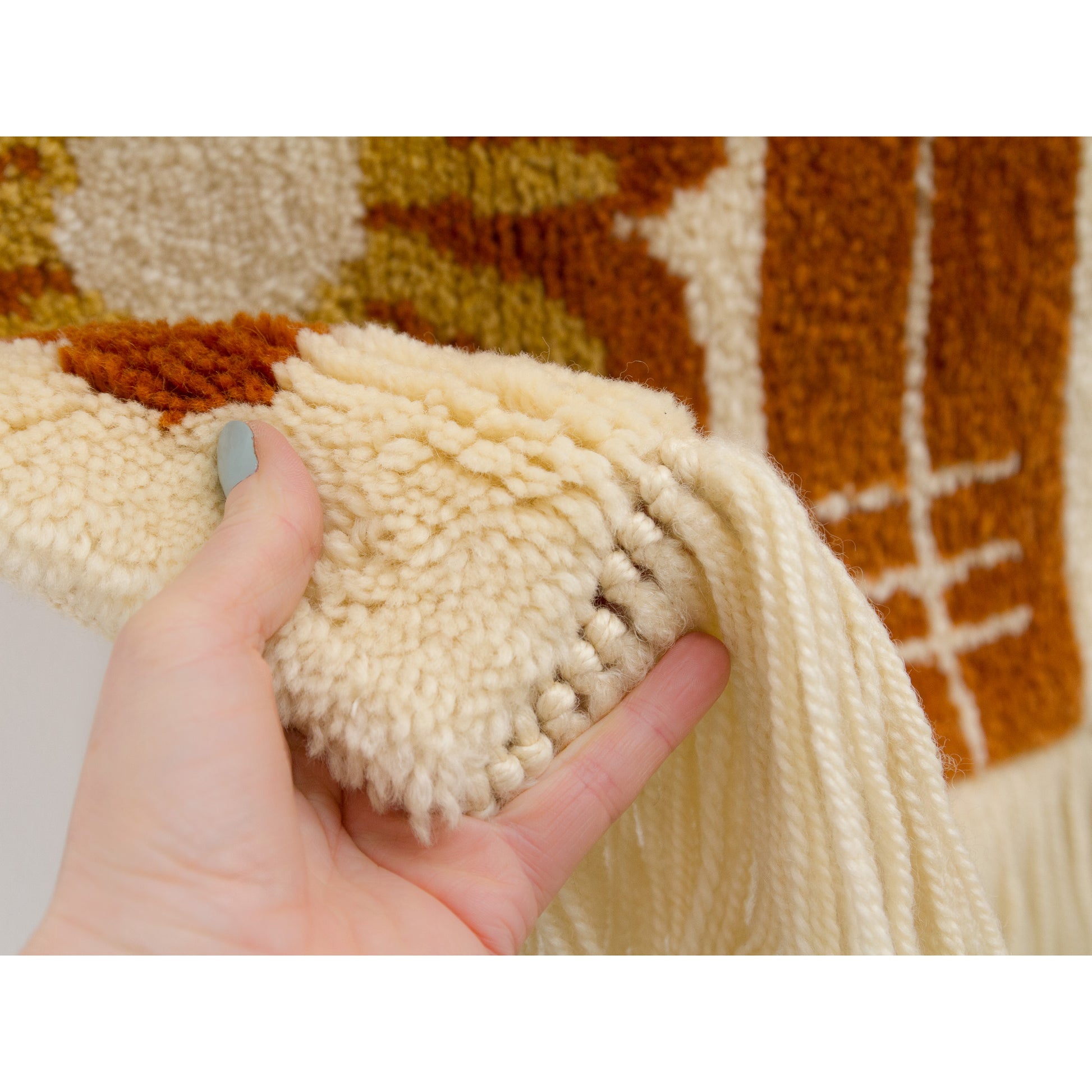 Extreme close-up of the dense wool knots. The thick texture provides acoustic dampening and warmth for the home.