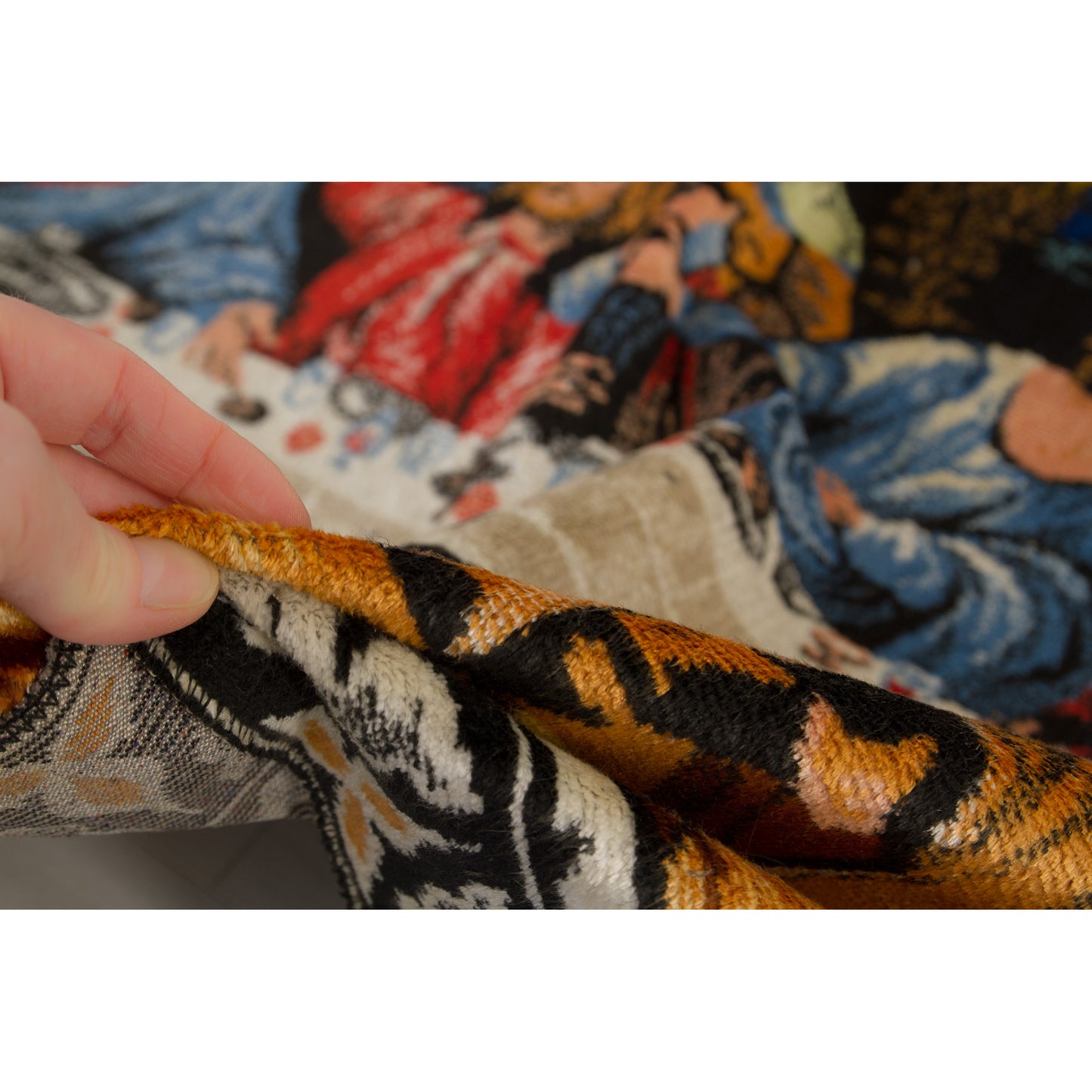 A hand lifting the large-scale moquette fabric, demonstrating the heavy, yet incredibly pliable, graceful drape and immaculate edge conditions of the tapestry.