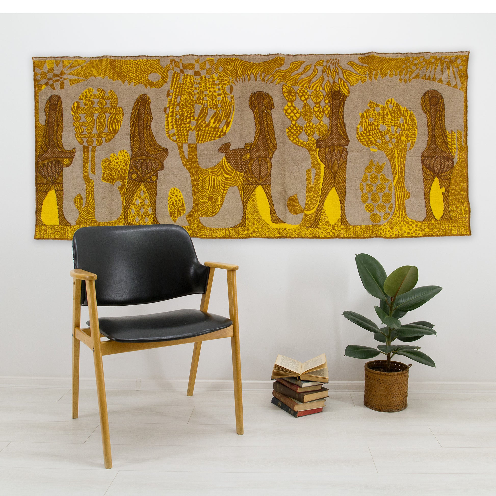 Large abstract textile art displayed in a modern 60s living room above a black leather armchair, offering fantastic acoustic softening and a warm visual focal point.