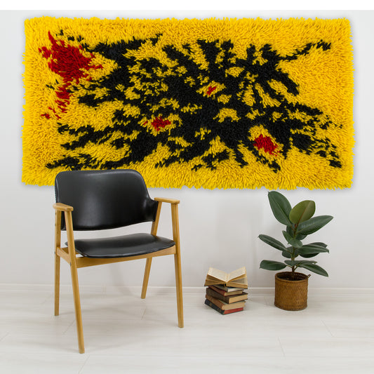 Bold yellow vintage mid-century tapestry styled as an accent floor rug under a modern black lounge chair and indoor plant, showing scale and vibrant colors.