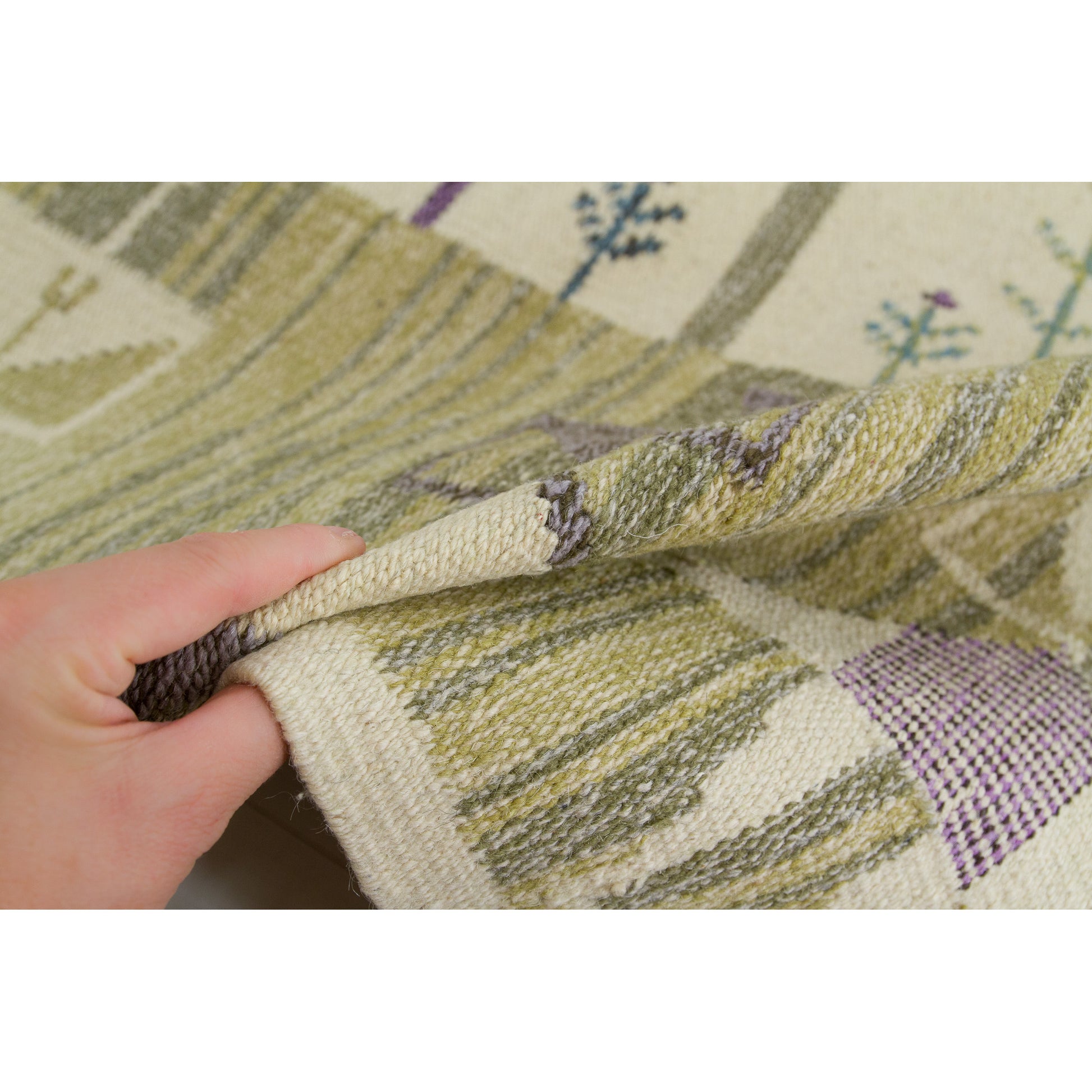Hand holding a heavy 1970s wool wall hanging to demonstrate the beautifully soft but thick acoustic drapery and texture of the woven material.