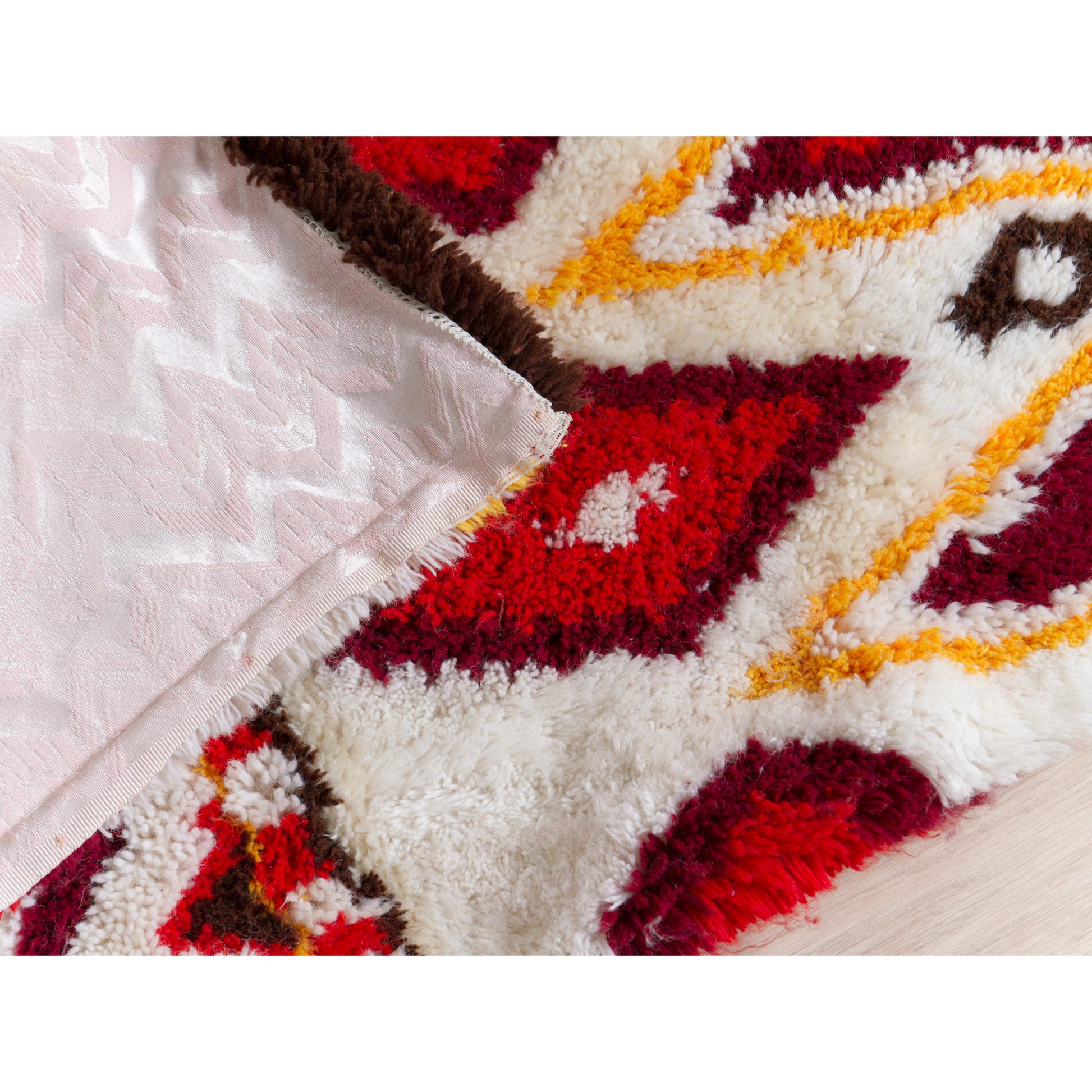 Corner of the vintage shag rug flipped up to seamlessly display both the meticulous hand-knotted pile construction on the front and the sturdy pink cotton lining on the back.