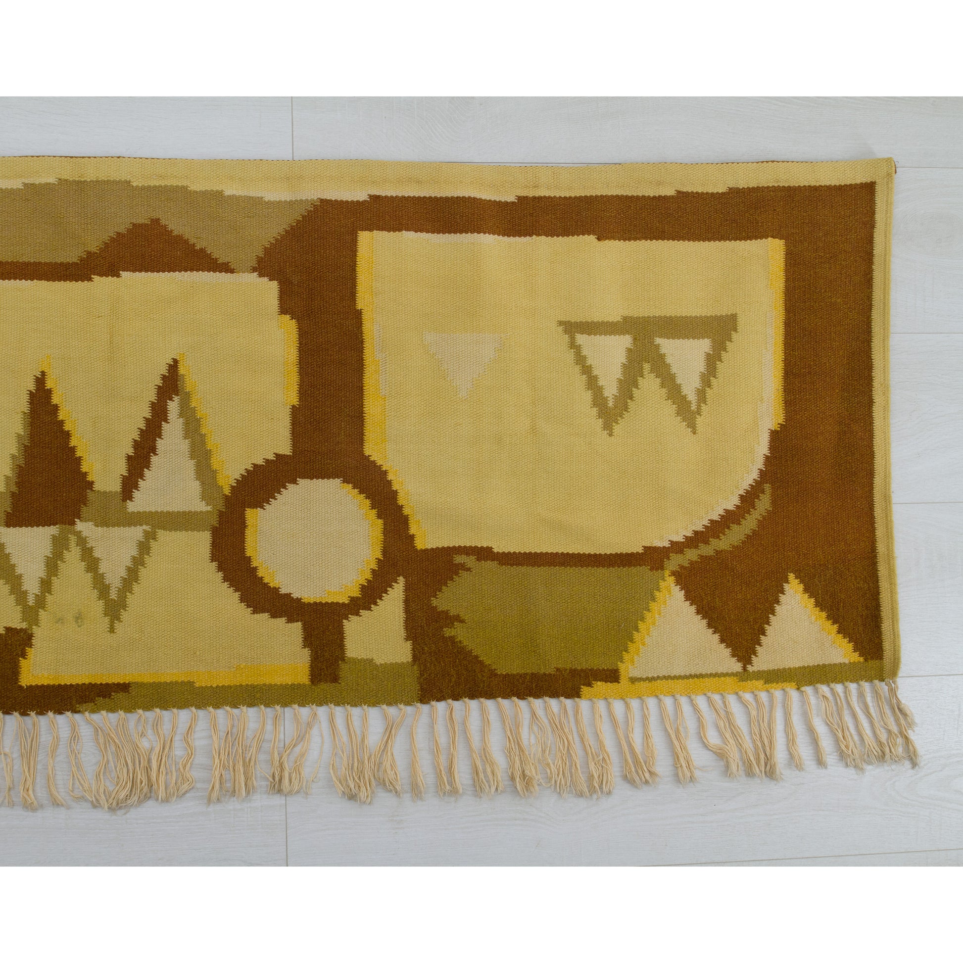 Right side of the large geometric textile art piece, highlighting the tight, durable flatweave texture dropping down into decorative cotton fringe.
