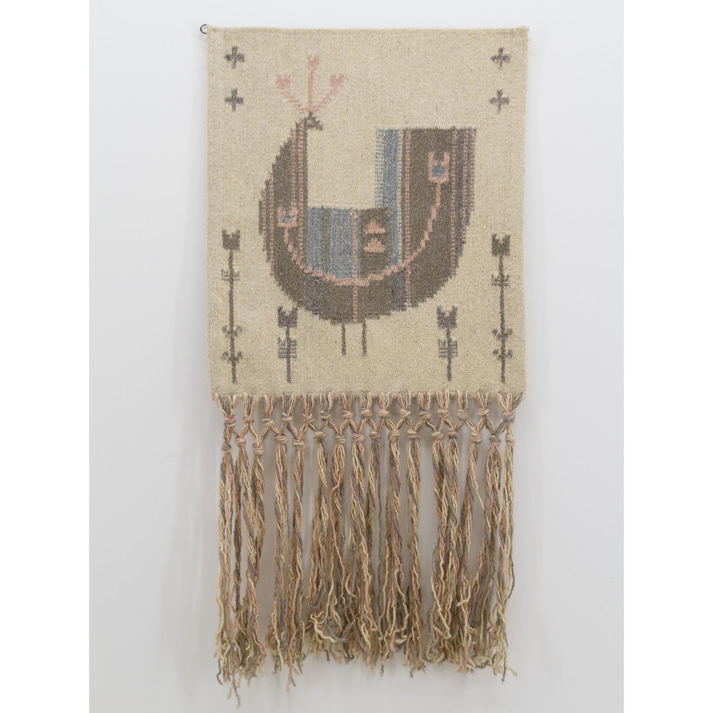 Full body, straight-on view of the vintage Scandinavian tapestry. Displays the large abstract bird pattern with extra long beige macrame fringe cascading below.