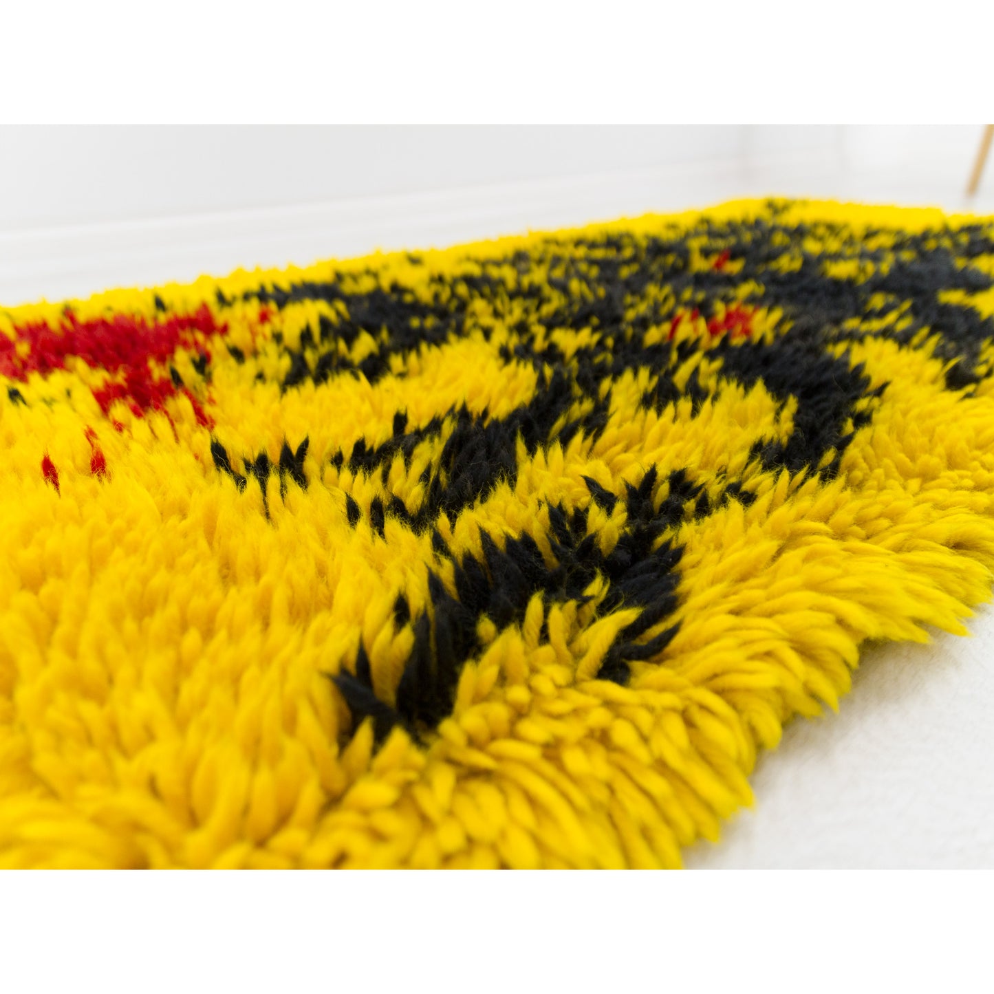 Angled view highlighting the deep texture of the screaming yellow abstract shag rug. A genuine mid-century modern tapestry perfect for 1970s retro home decor, as a floor rug or wall hanging alike.