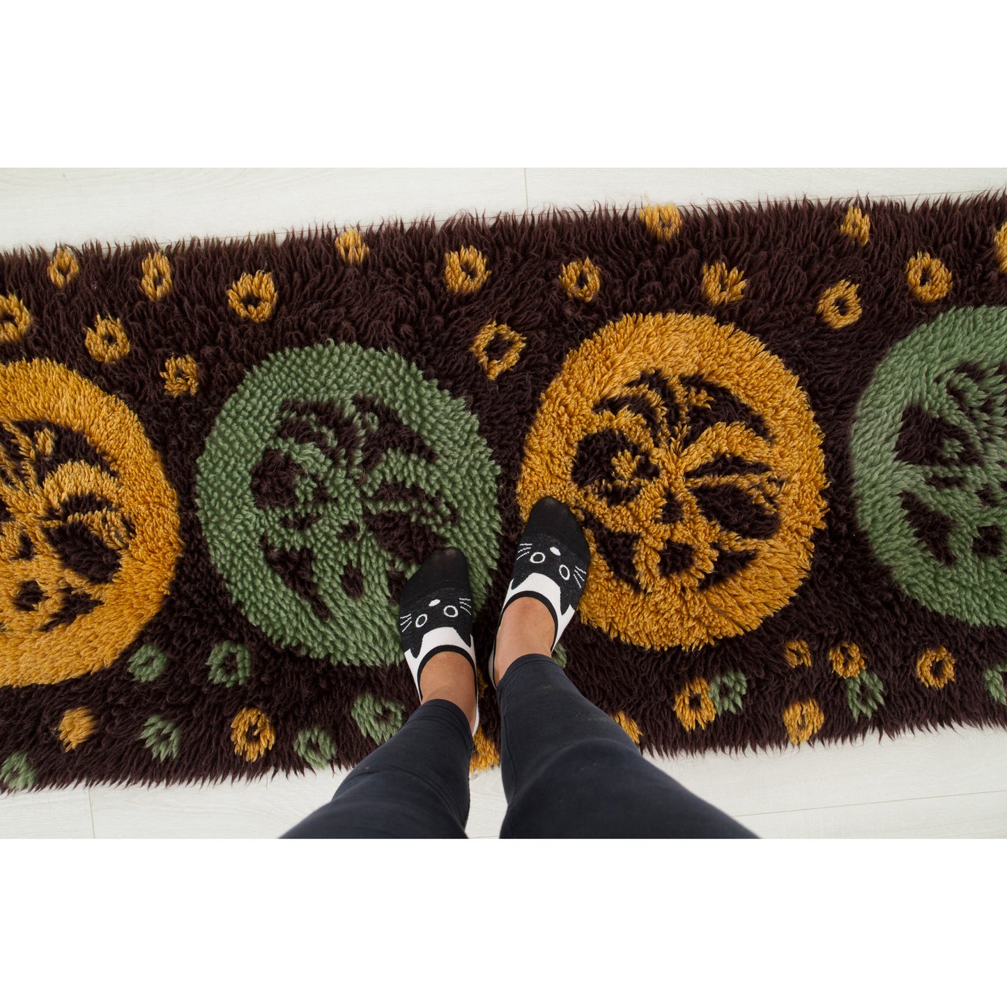 A playful perspective with feet standing on the vintage shag rug, giving interior stylists an instant understanding of the 71-inch impressive length scale for their home.
