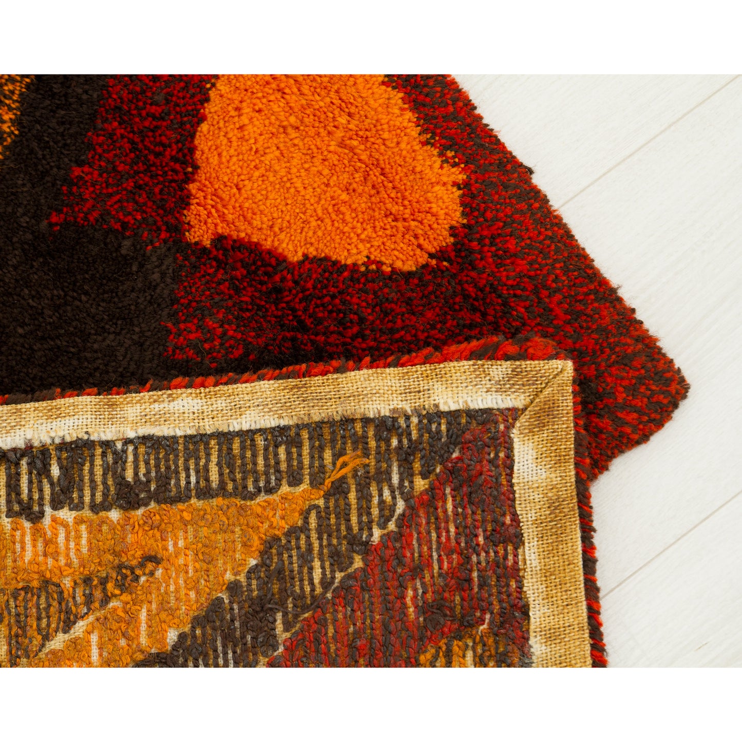 High-contrast corner fold. Showcases the brilliant orange pile of the decorative face perfectly meeting the reinforced woven textile back structure.