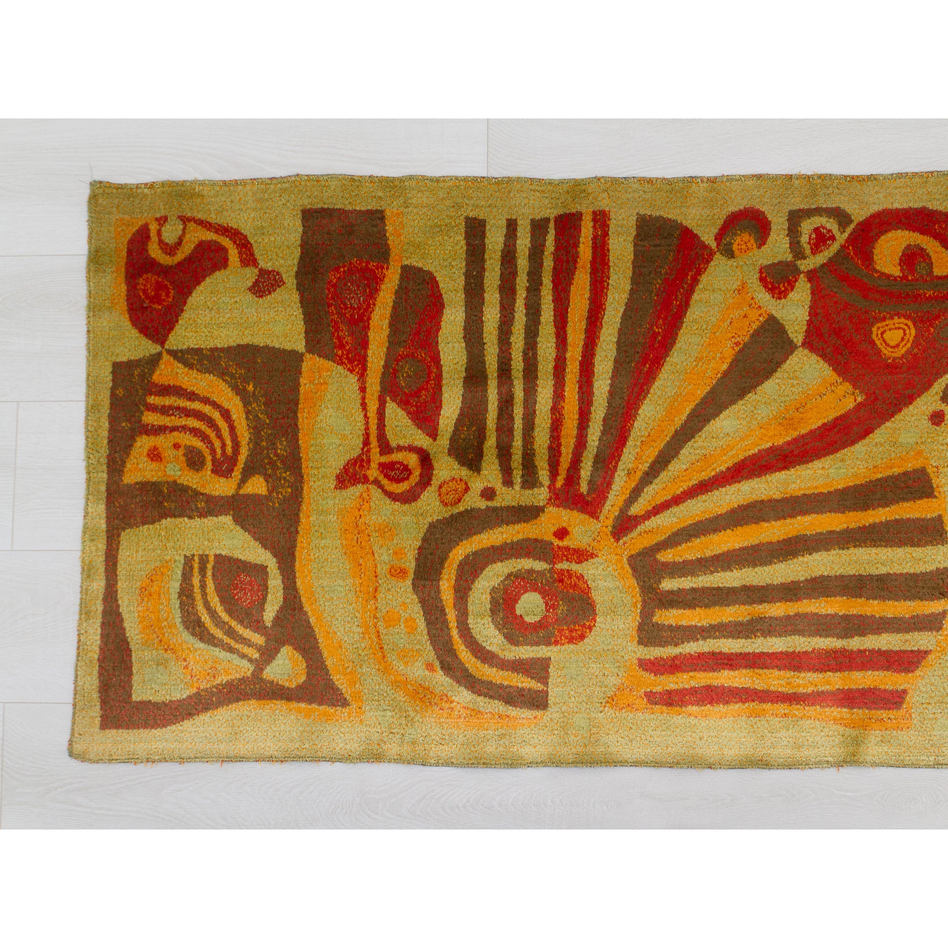 Close-up of the tapestry's left section showing dynamic, organic shapes resembling mid-century abstract art. The palette features deep russet red and warm beige on a mossy green-gold background.