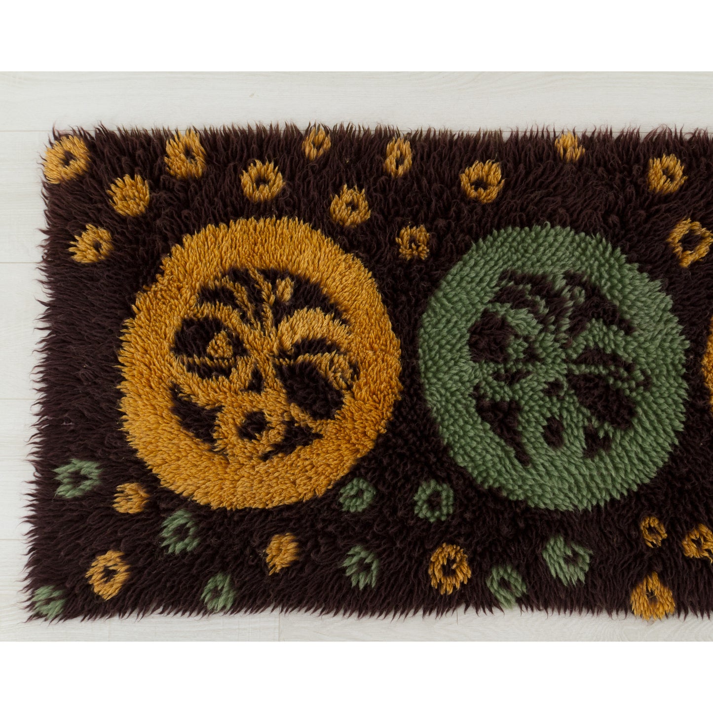 Clear photography of the left-hand section highlighting the crisp, vivid colors of the deep mustard yellow dots and circle forms securely knotted into the brown fabric base.