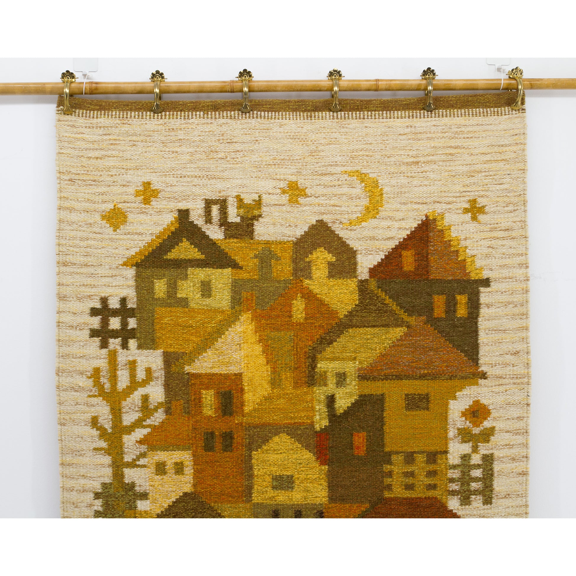 Detailed view of the top section highlighting beautifully woven geometric stars, a crescent moon, and chimney details crafted from rich brown and mustard yarn.