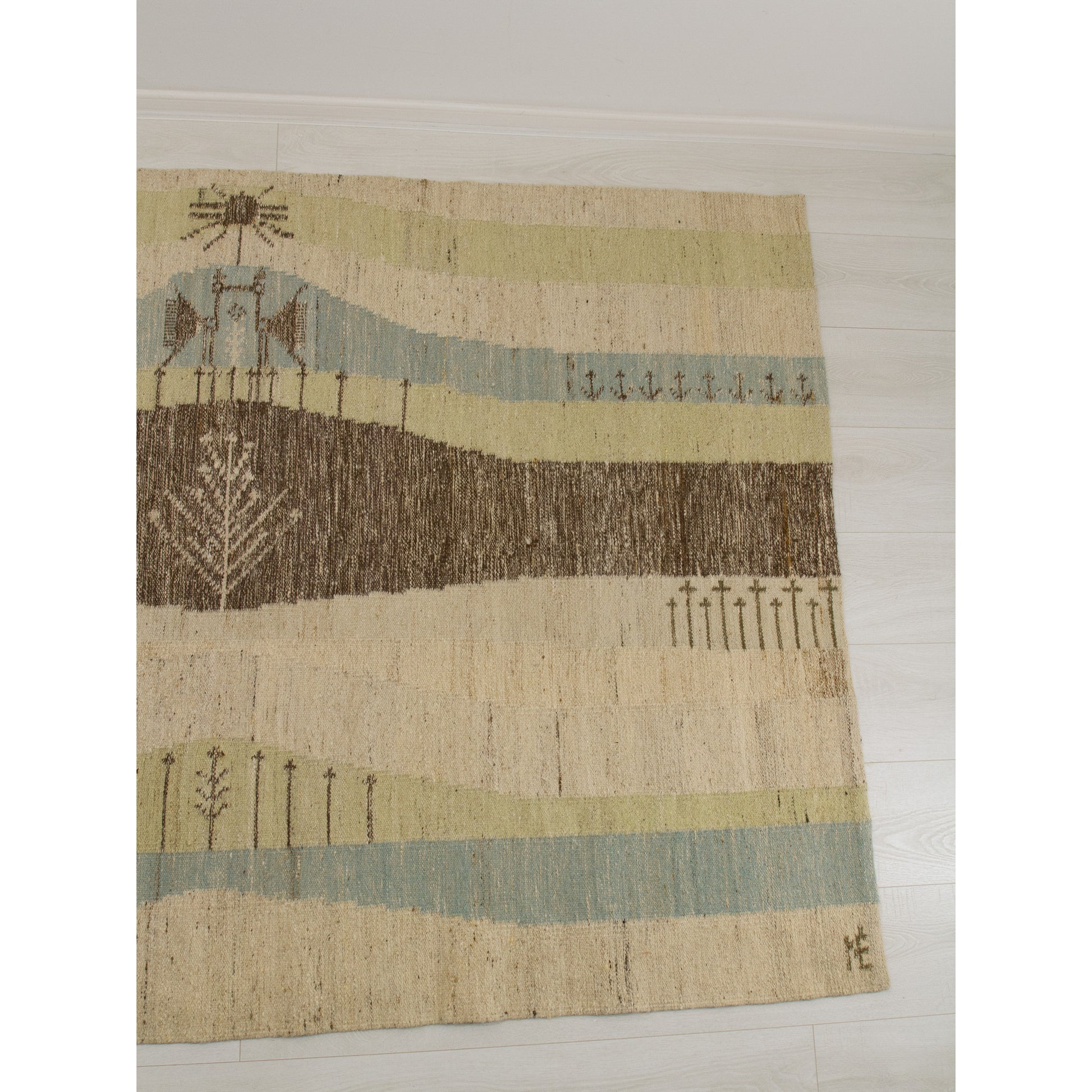 The right panel of the mid century tapestry featuring Nordic folk art inspired birds, sun motifs, and wavy horizon lines handwoven into premium wool.