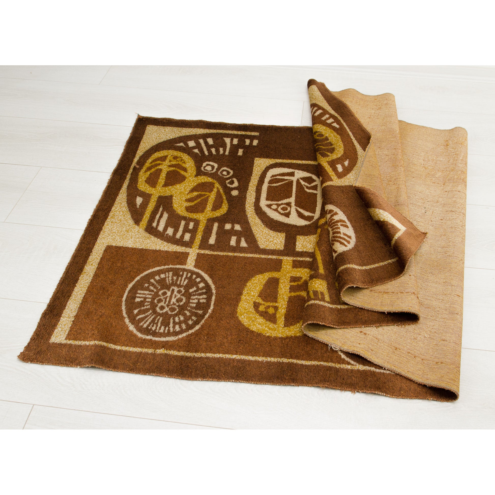 The vintage brown tapestry folded to show both the plush moquette front and the sturdy beige woven reverse side. Highlights the durable construction of the mid century textile art.