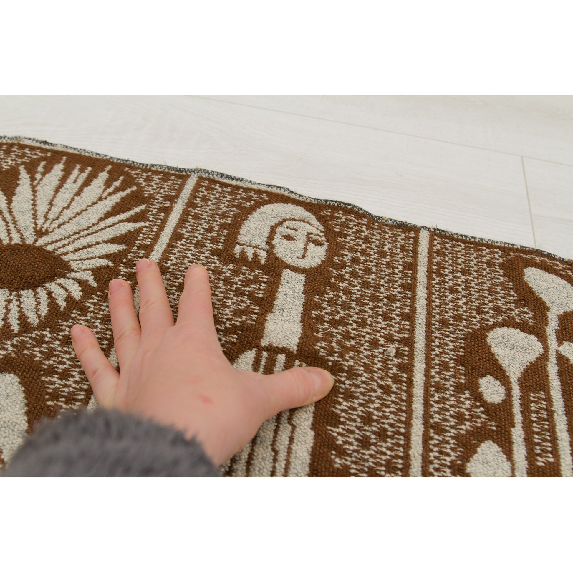 Hand touching the surface of the vintage tapestry, showing the medium-weight, soft cotton weave that mimics the texture of bouclé wool. High-quality heavy textile.