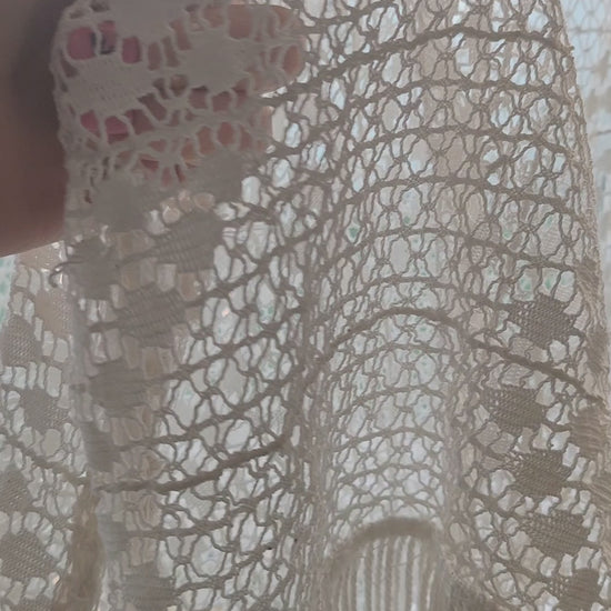 Video of a large vintage crochet lace curtain in creamy white, showing close-ups of the delicate lace pattern and fringe against the window light