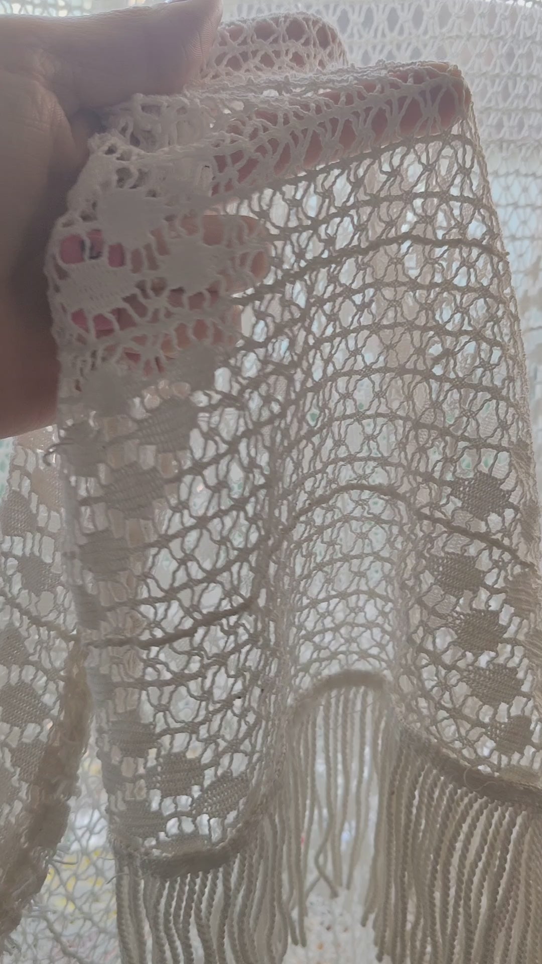 Video of a large vintage crochet lace curtain in creamy white, showing close-ups of the delicate lace pattern and fringe against the window light
