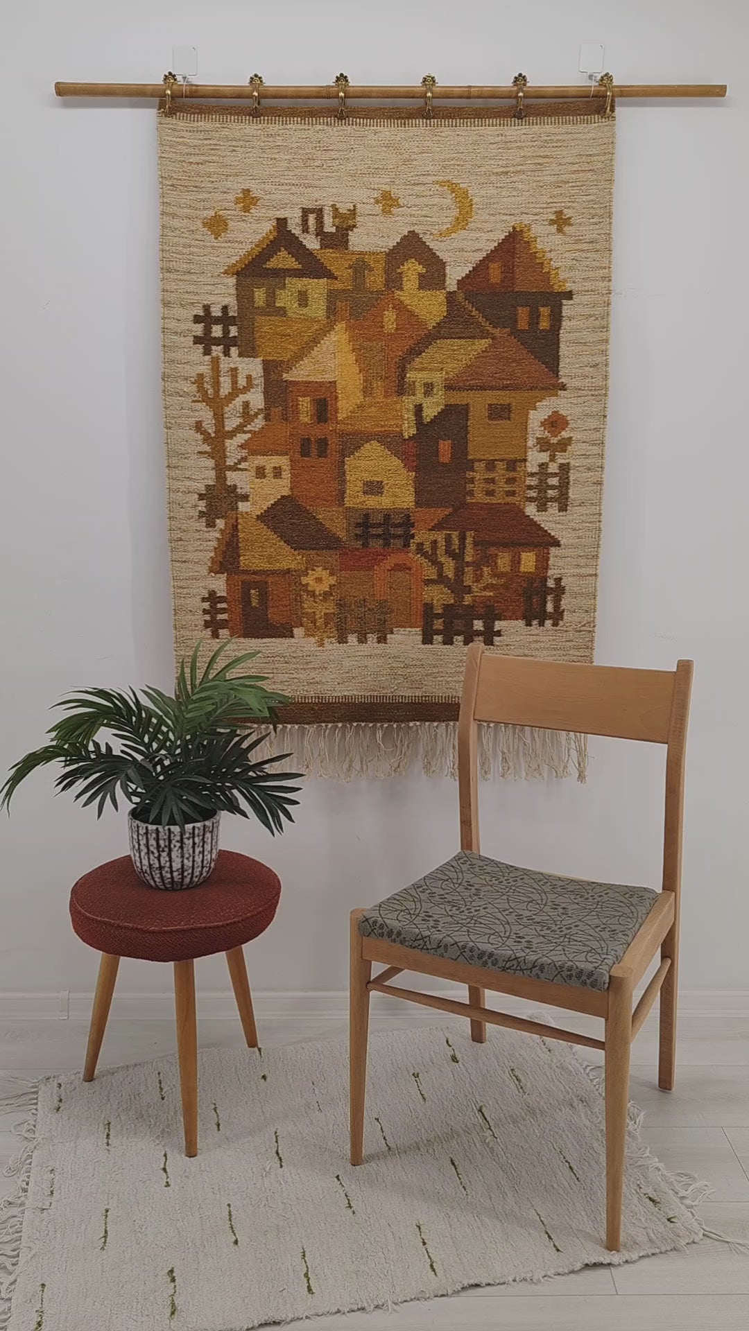 A detailed, sweeping video panning over a yellow and brown 1970s vintage tapestry, with a hand tightly squeezing the high-quality flatwoven fibers. Mellow, warm colors in a stylized, geometric design.